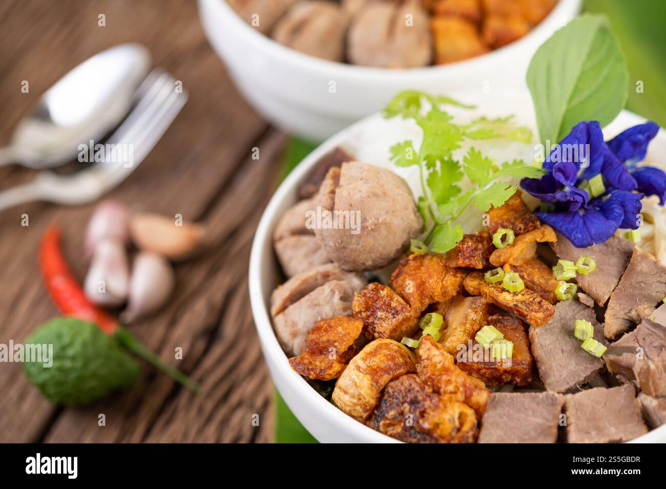 Nouilles dans une tasse avec du porc croustillant, des tranches de porc et des boulettes de viande avec des nouilles thaïlandaises Banque D'Images