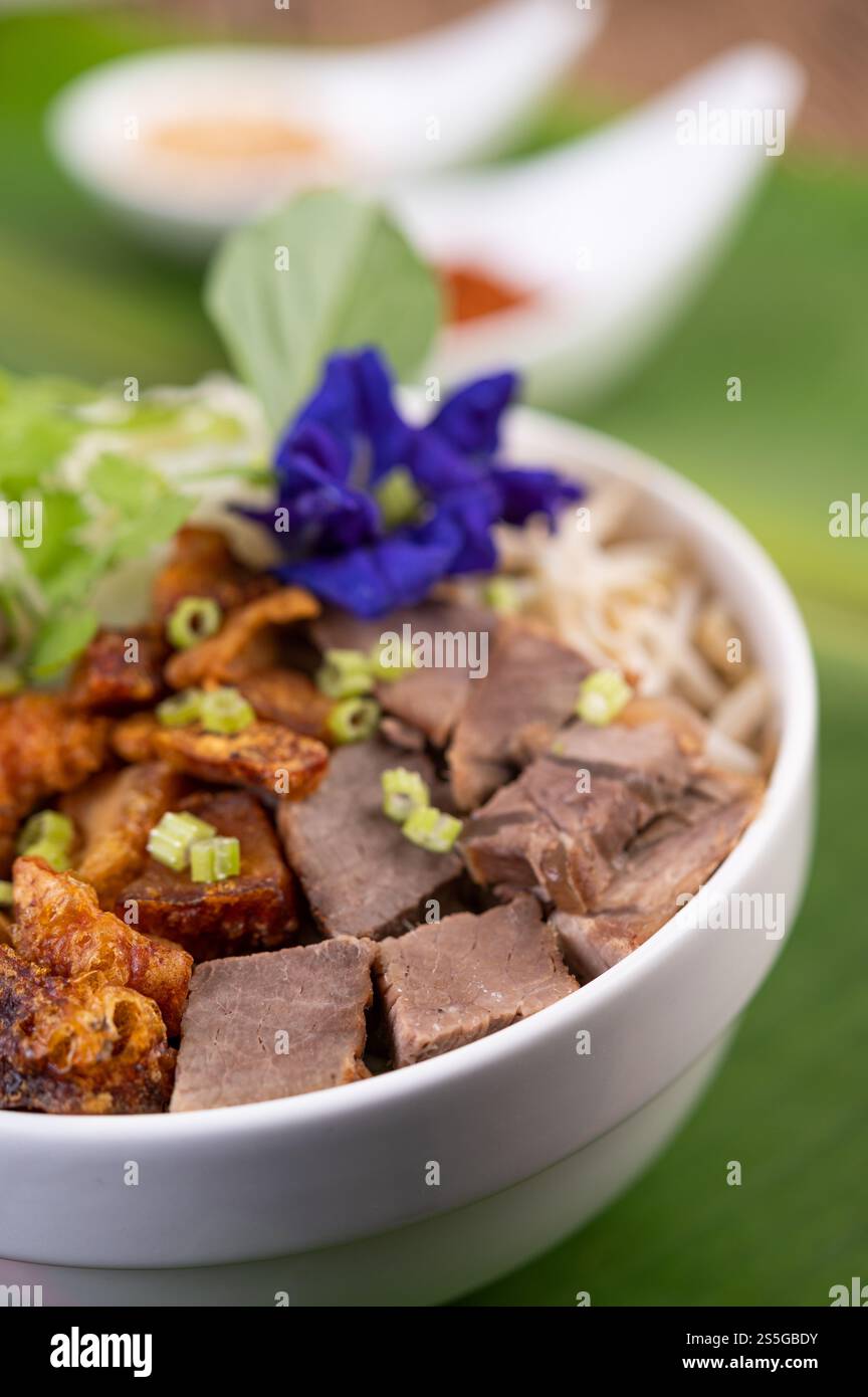 Nouilles jaunes dans une tasse avec du porc croustillant, des tranches de porc et des boulettes de viande avec des nouilles thaïlandaises Banque D'Images