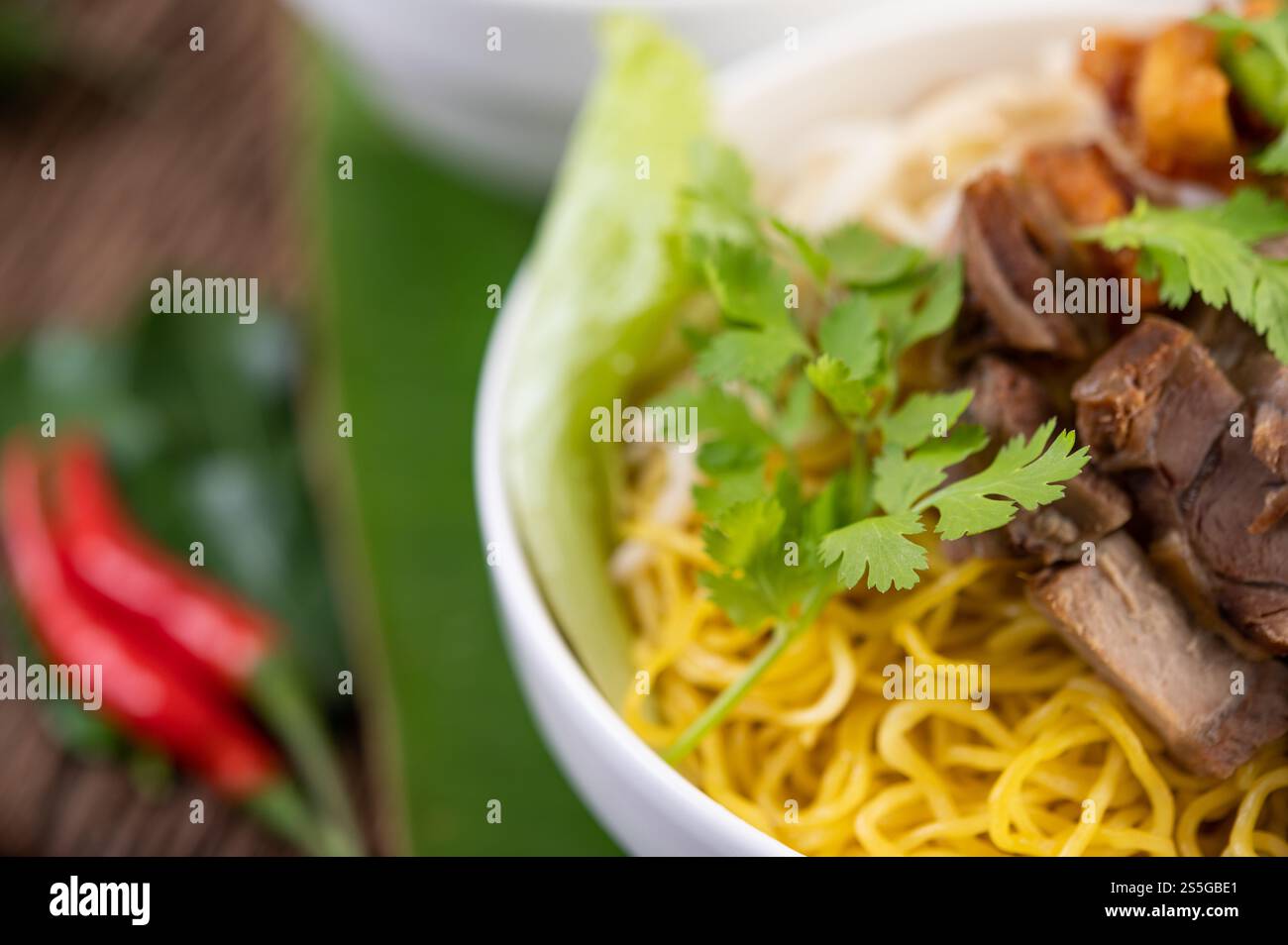 Nouilles jaunes dans une tasse avec du porc croustillant, des tranches de porc et des boulettes de viande avec des nouilles thaïlandaises Banque D'Images