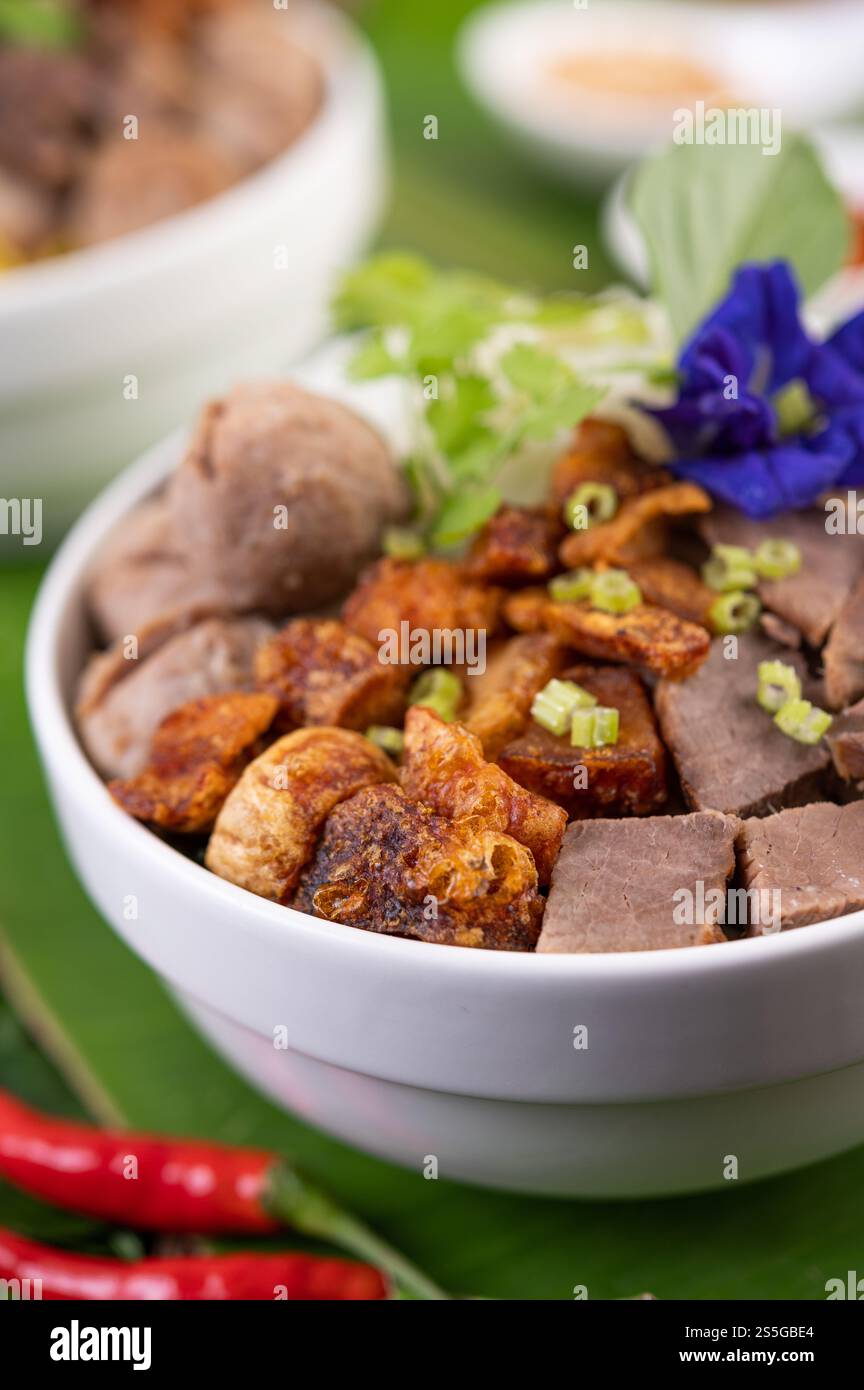 Nouilles jaunes dans une tasse avec du porc croustillant, des tranches de porc et des boulettes de viande avec des nouilles thaïlandaises Banque D'Images