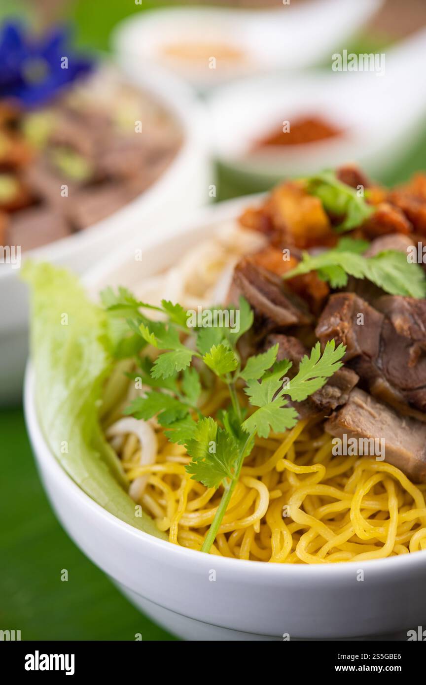 Nouilles jaunes dans une tasse avec du porc croustillant, des tranches de porc et des boulettes de viande avec des nouilles thaïlandaises Banque D'Images
