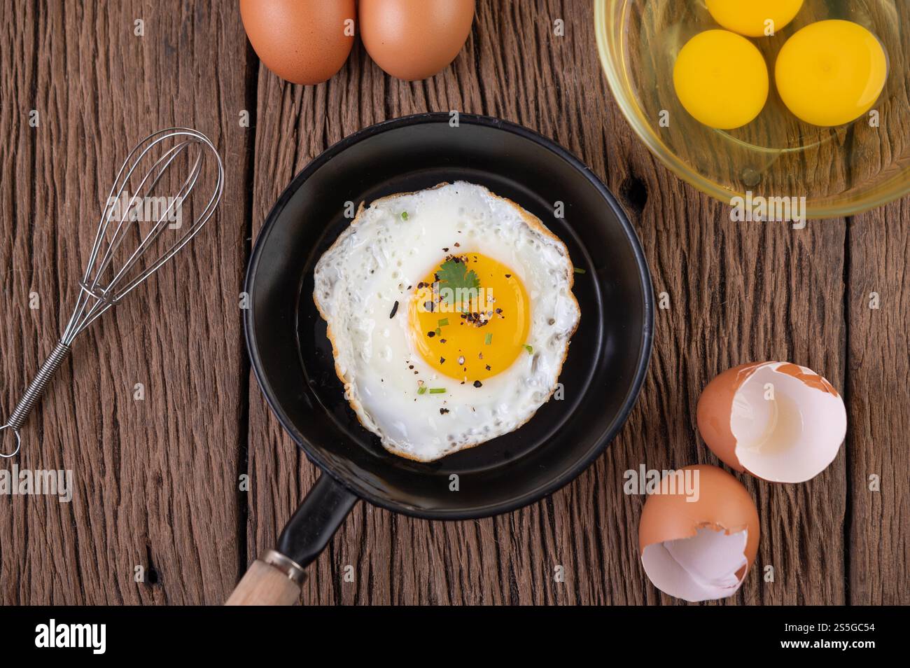 Oeufs frits dans une poêle et oeufs crus, aliments biologiques pour une bonne santé, riches en protéines Banque D'Images