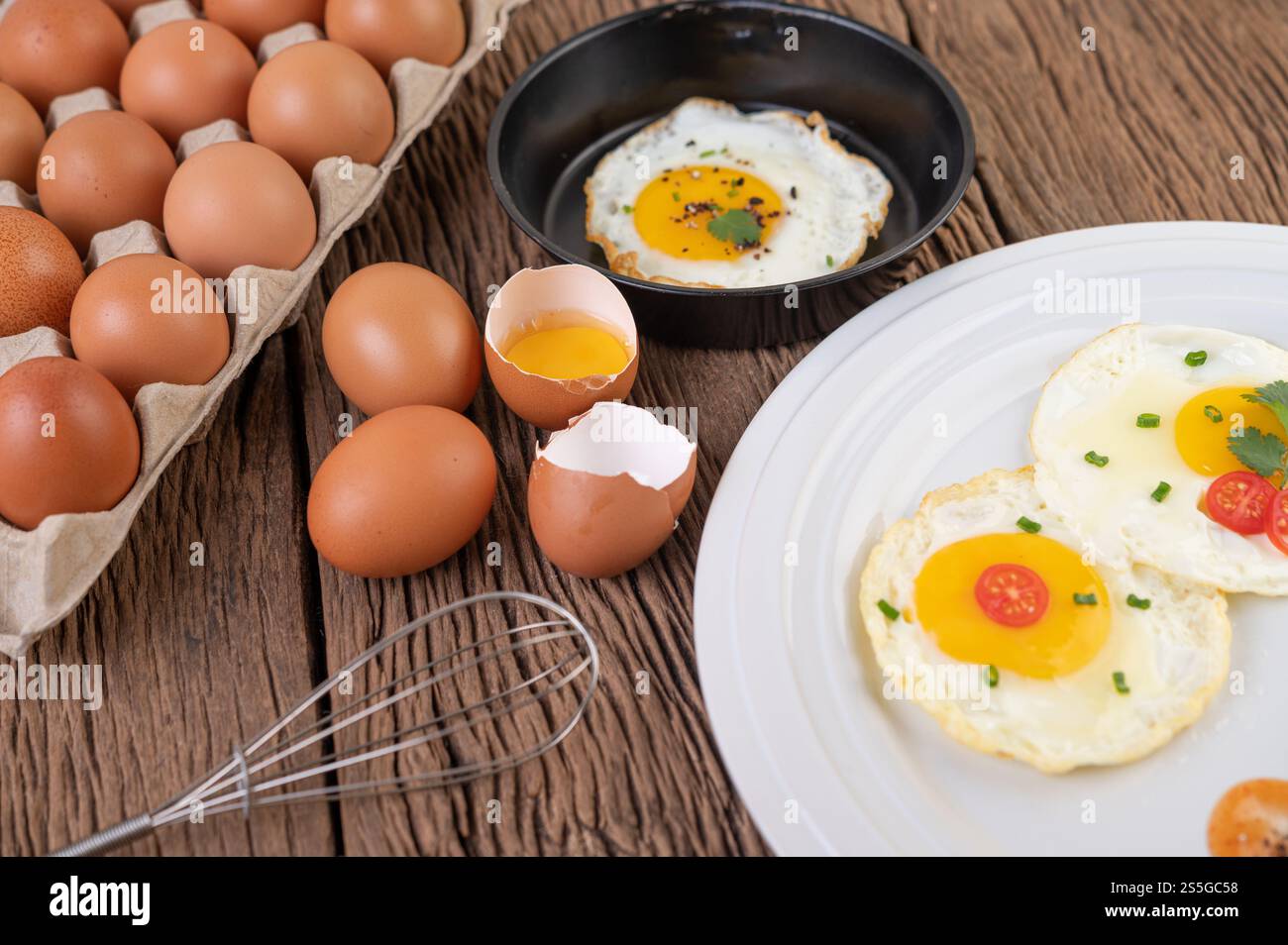 Oeufs frits dans une poêle et oeufs crus, aliments biologiques pour une bonne santé, riches en protéines. Banque D'Images
