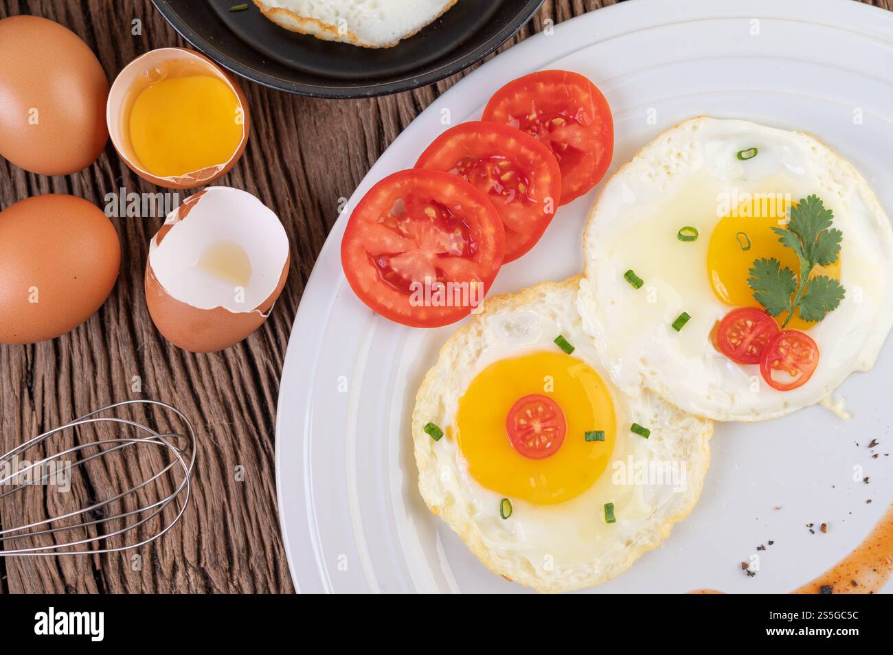 Oeufs frits dans une poêle et oeufs crus, aliments biologiques pour une bonne santé, riches en protéines. Banque D'Images