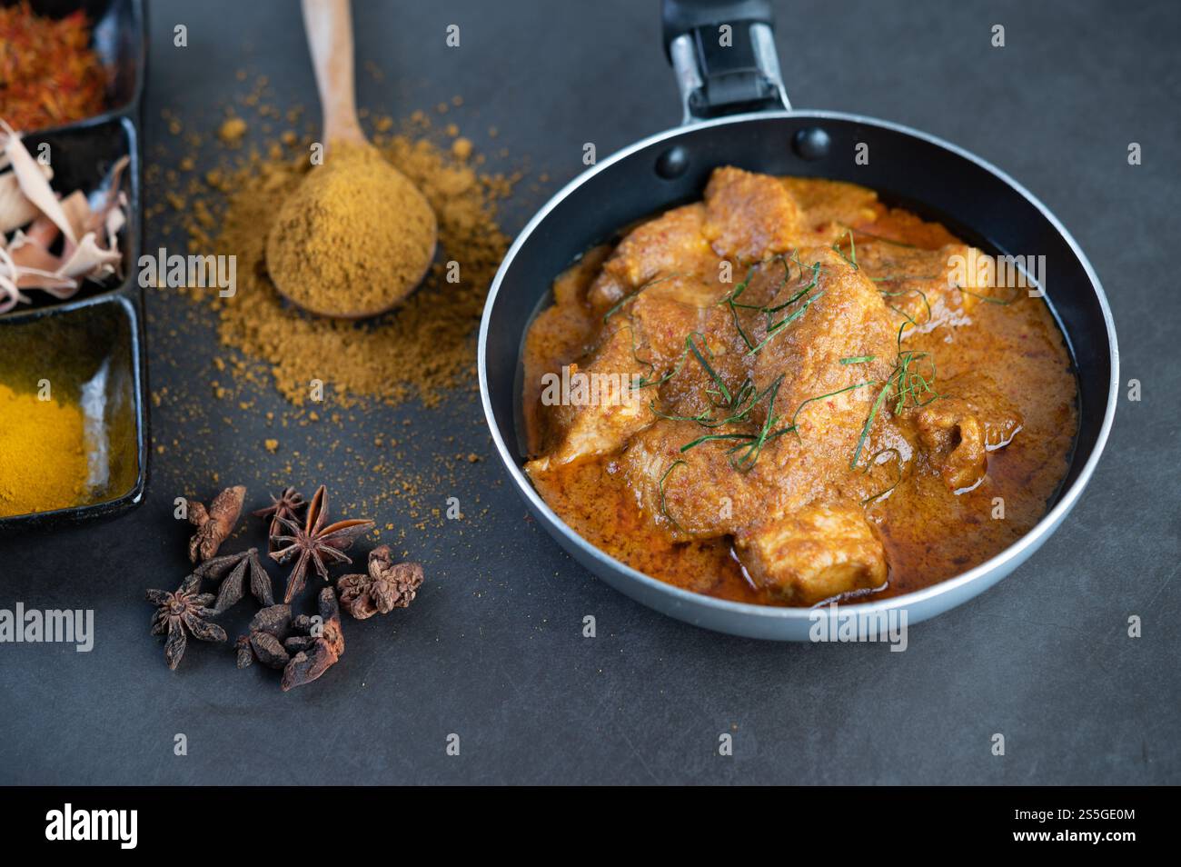 Curry Massaman dans une poêle avec des épices sur le sol en ciment. Mise au point sélective Banque D'Images