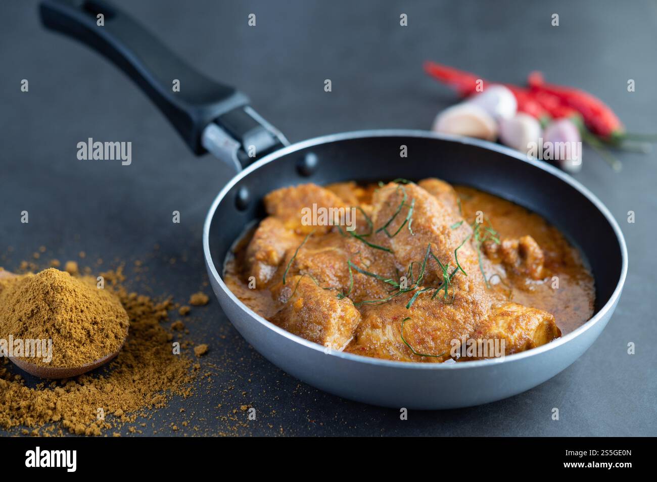 Curry Massaman dans une poêle avec des épices sur le sol en ciment. Mise au point sélective Banque D'Images
