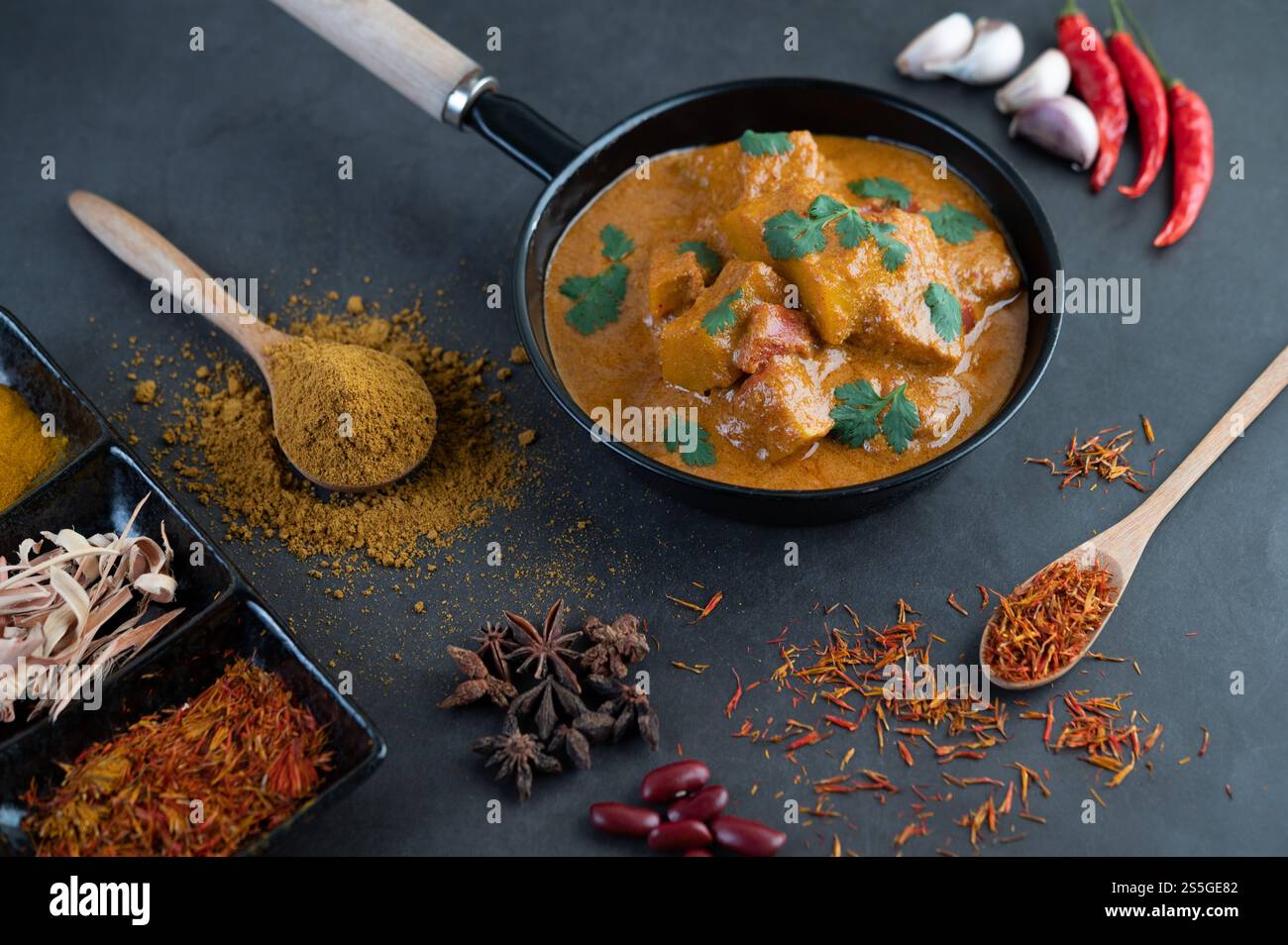 Curry Massaman dans une poêle avec des épices sur le sol en ciment. Mise au point sélective Banque D'Images
