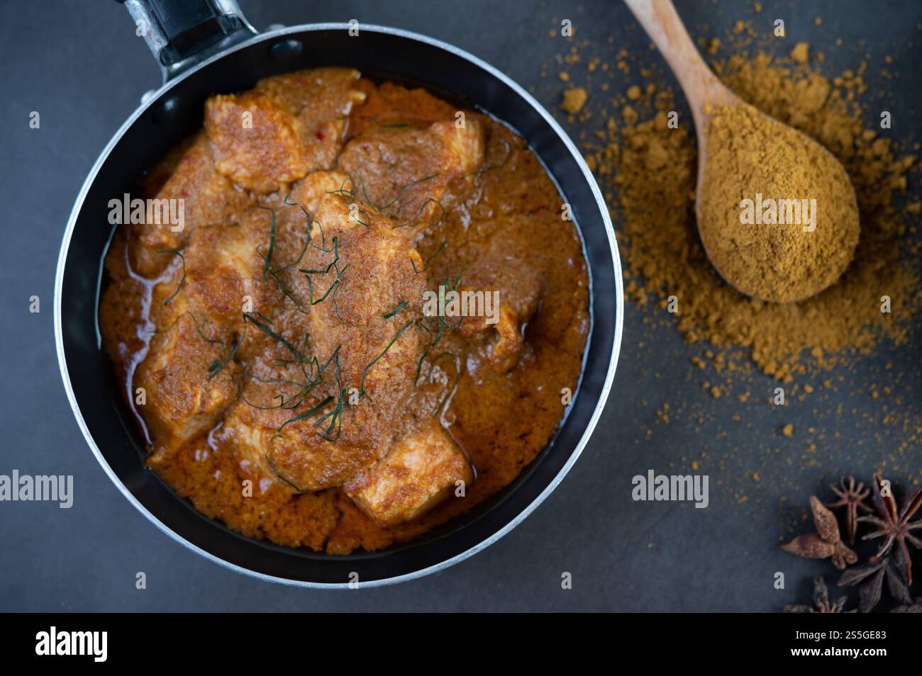 Curry Massaman dans une poêle avec des épices sur le sol en ciment. Mise au point sélective Banque D'Images