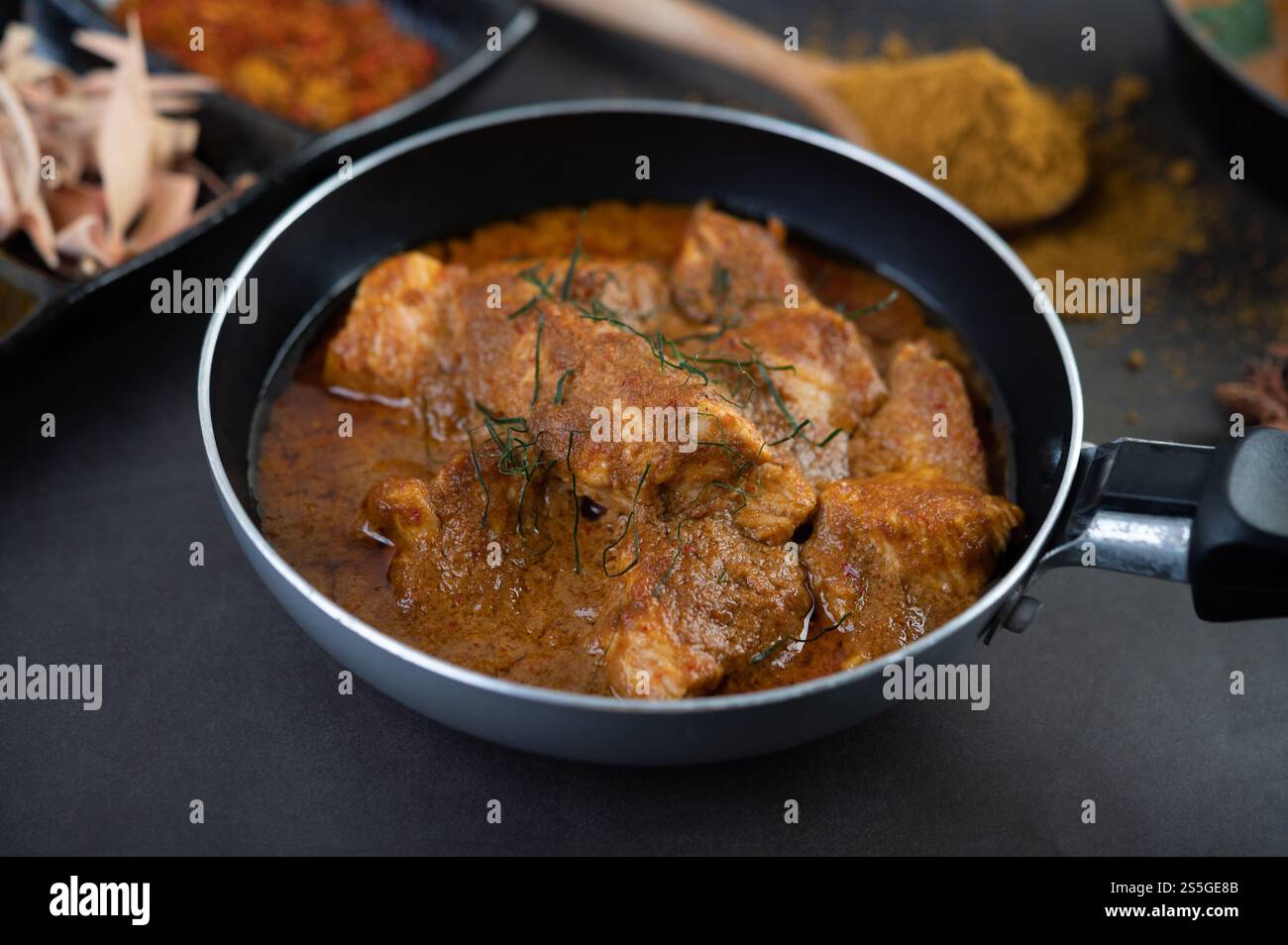 Curry Massaman dans une poêle avec des épices sur le sol en ciment. Mise au point sélective Banque D'Images