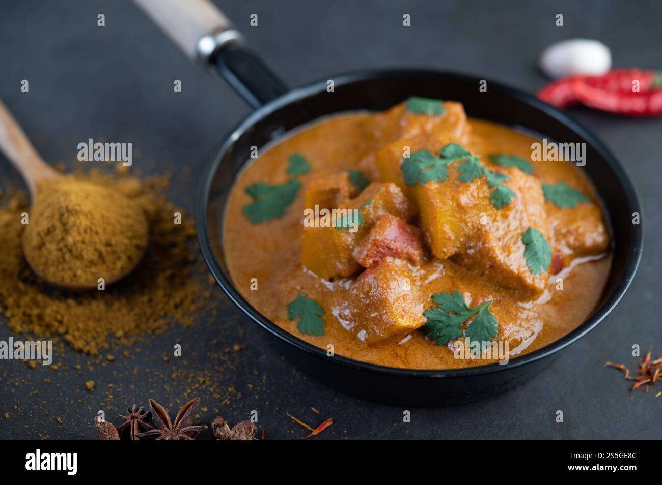 Curry Massaman dans une poêle avec des épices sur le sol en ciment. Mise au point sélective Banque D'Images
