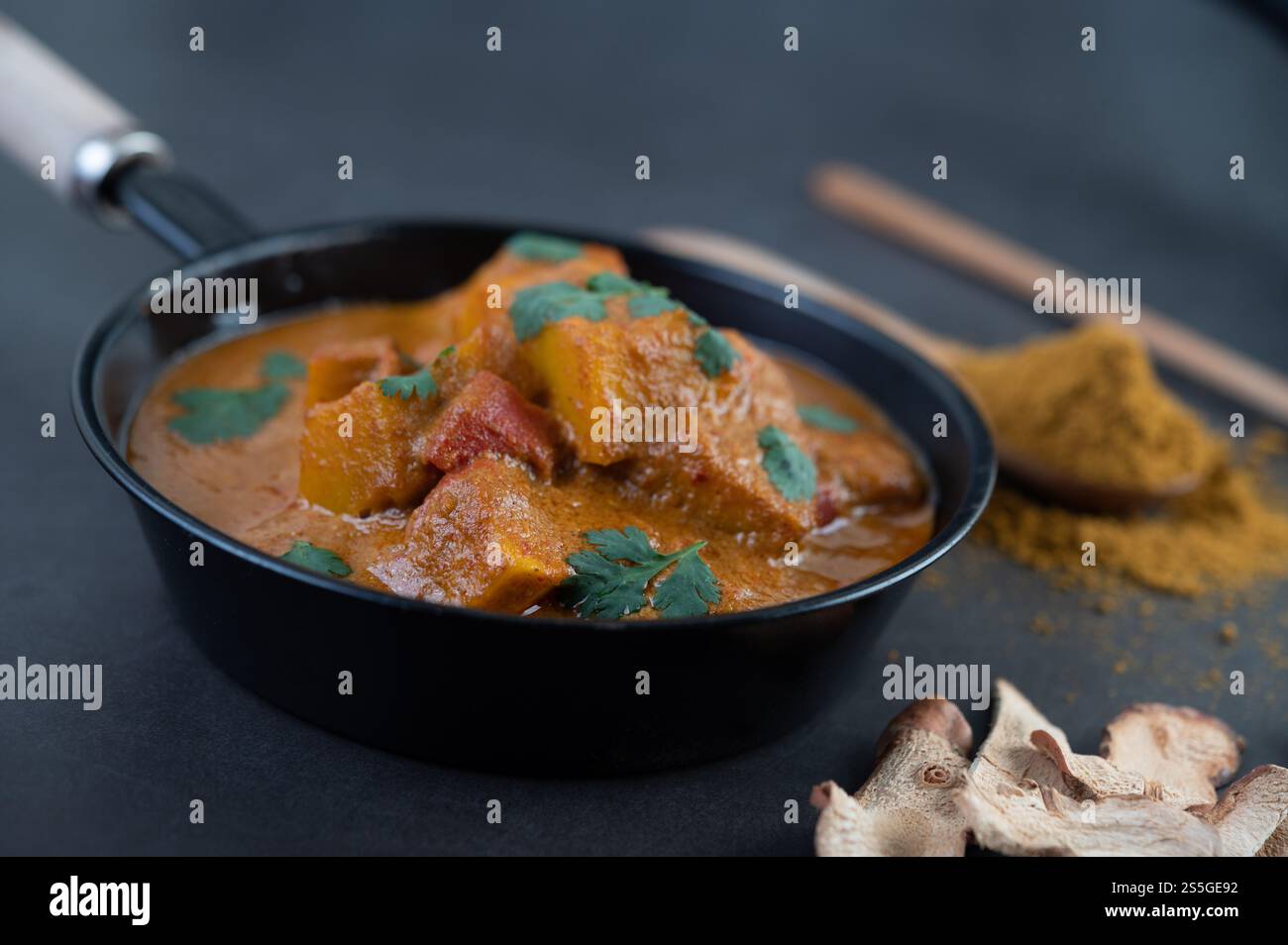 Curry Massaman dans une poêle avec des épices sur le sol en ciment. Mise au point sélective Banque D'Images