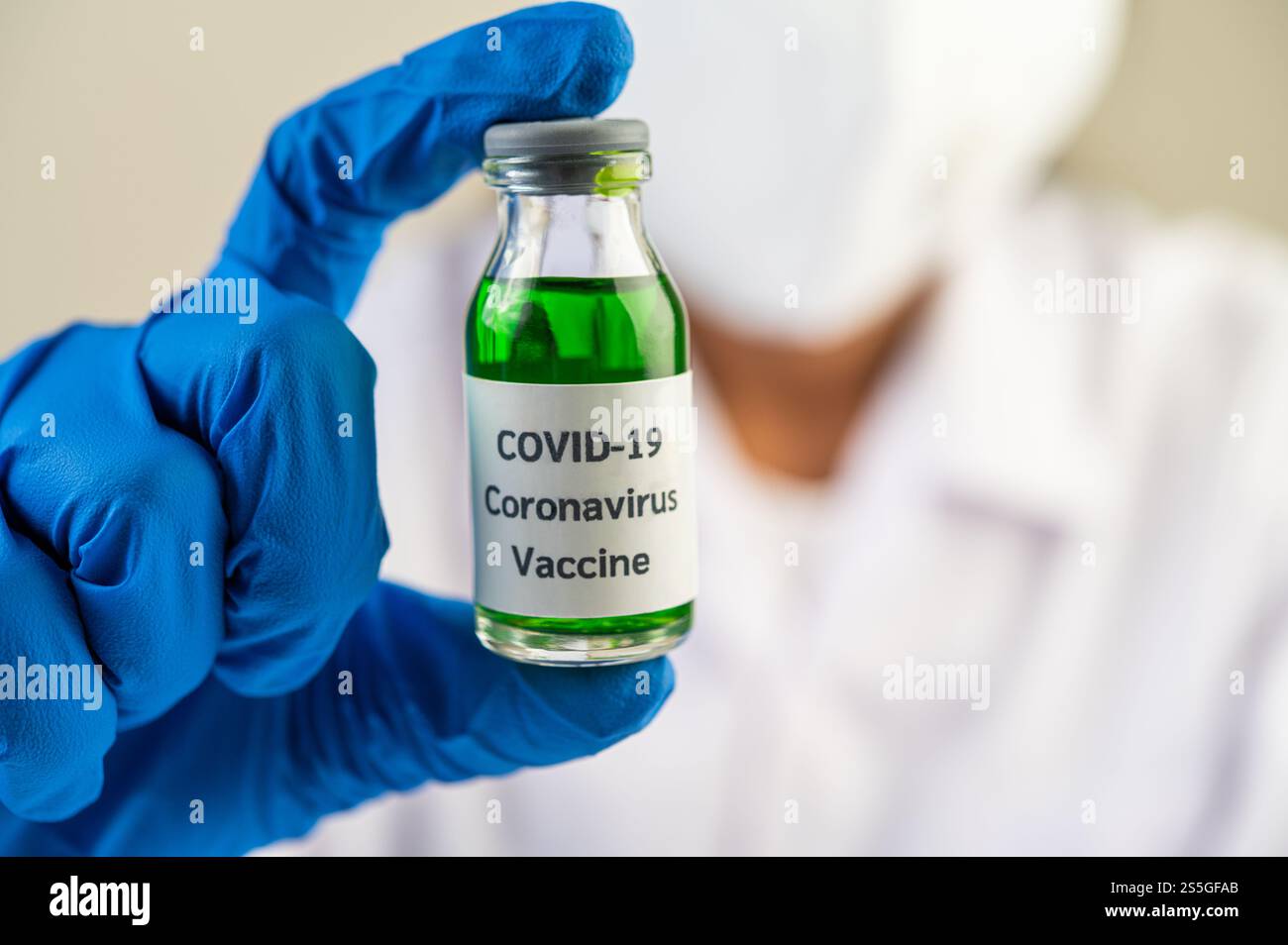 Les scientifiques portent des masques et des gants, portant des fioles avec des vaccins pour protéger COVID-19 Banque D'Images