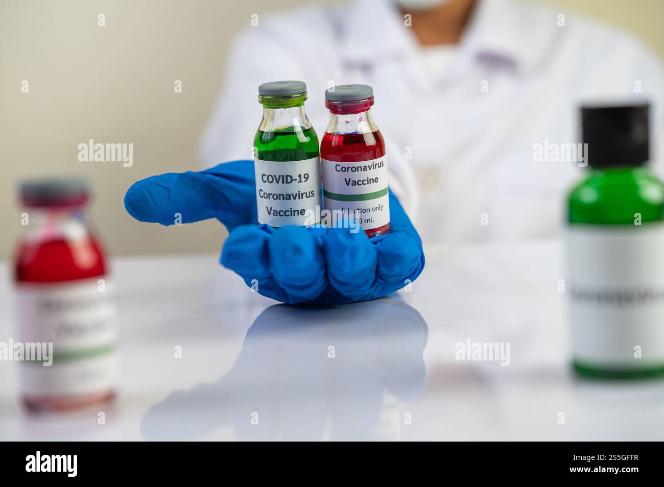 Les scientifiques portent des masques et des gants, portant des fioles avec des vaccins pour protéger COVID-19 Banque D'Images