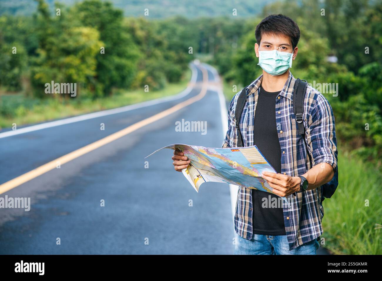 Les touristes masculins se tiennent debout et regardent la carte sur la route. Banque D'Images