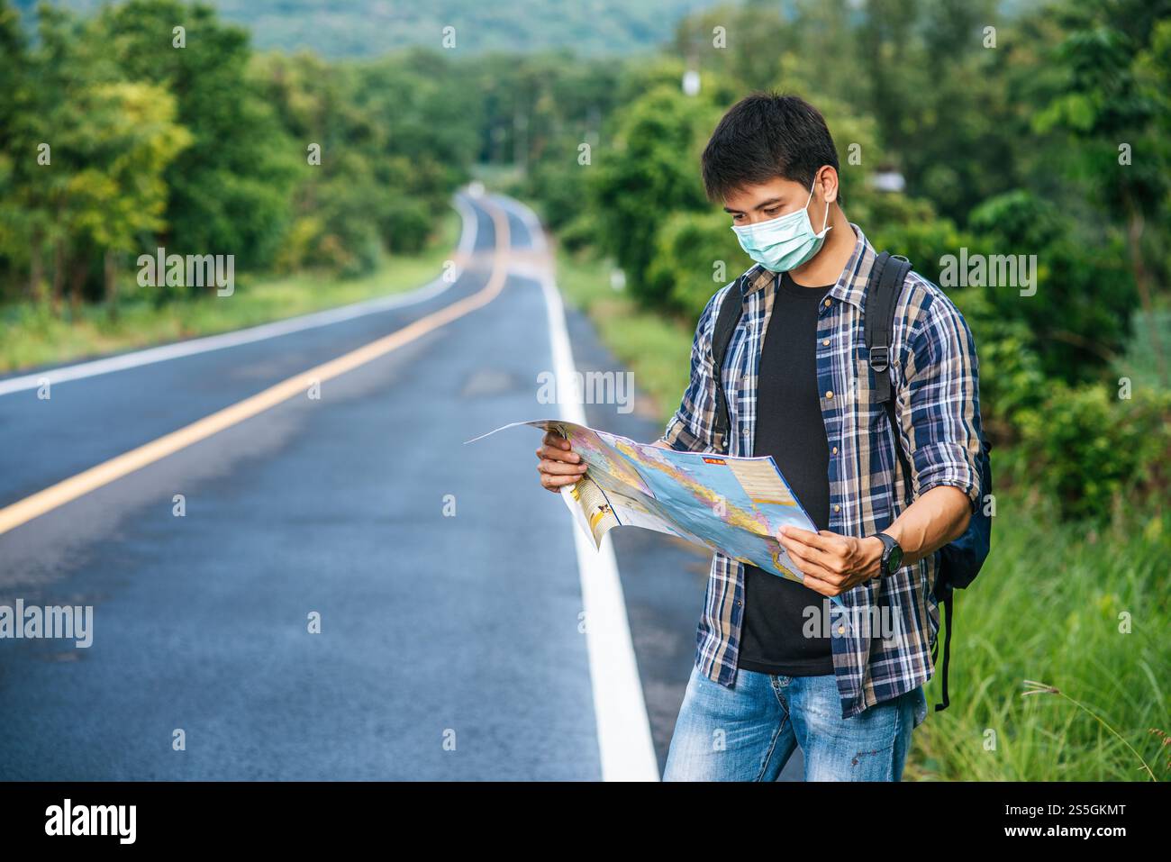 Les touristes masculins se tiennent debout et regardent la carte sur la route. Banque D'Images