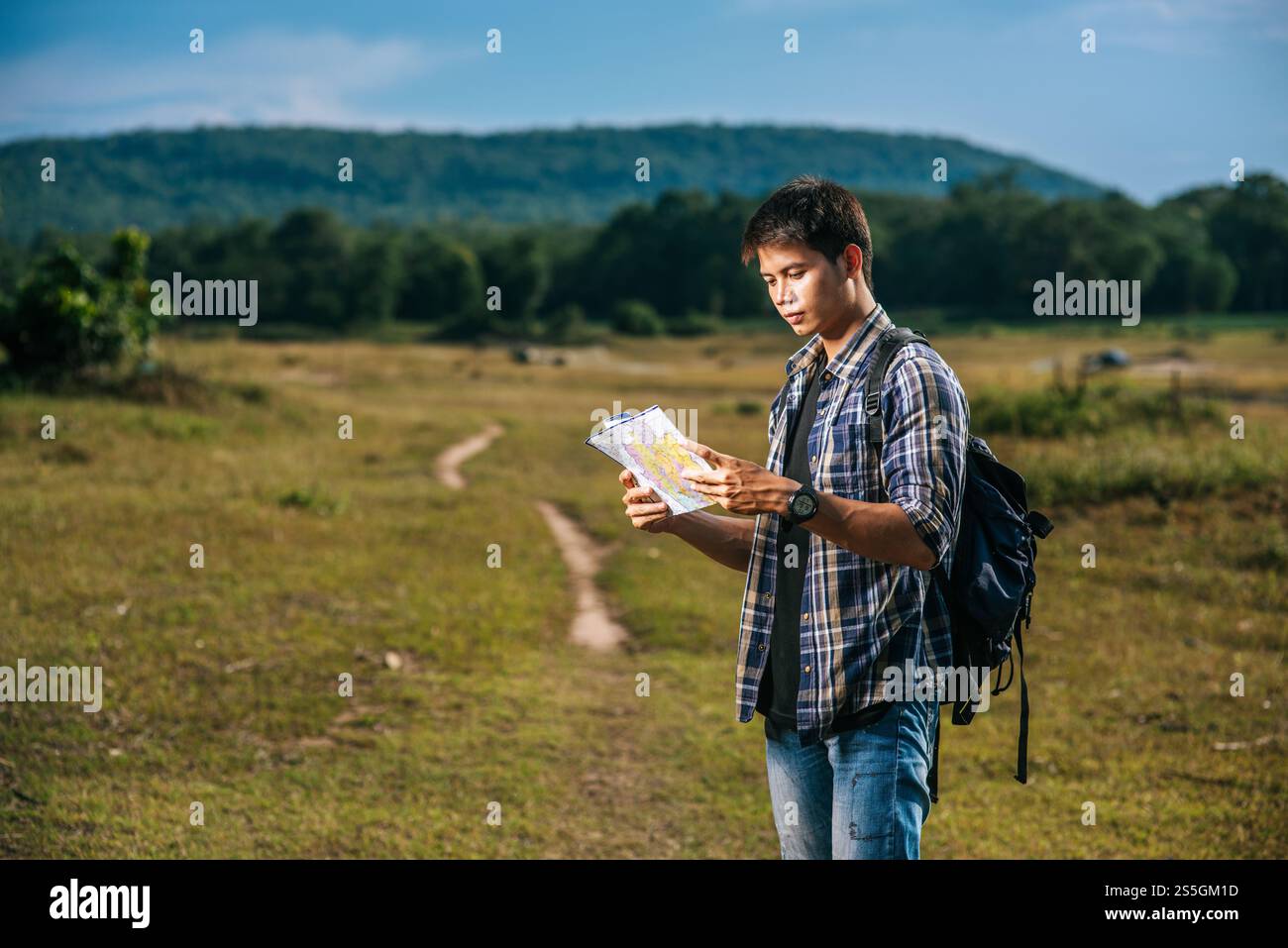 Les touristes masculins se tiennent debout et regardent la carte sur la pelouse. Banque D'Images