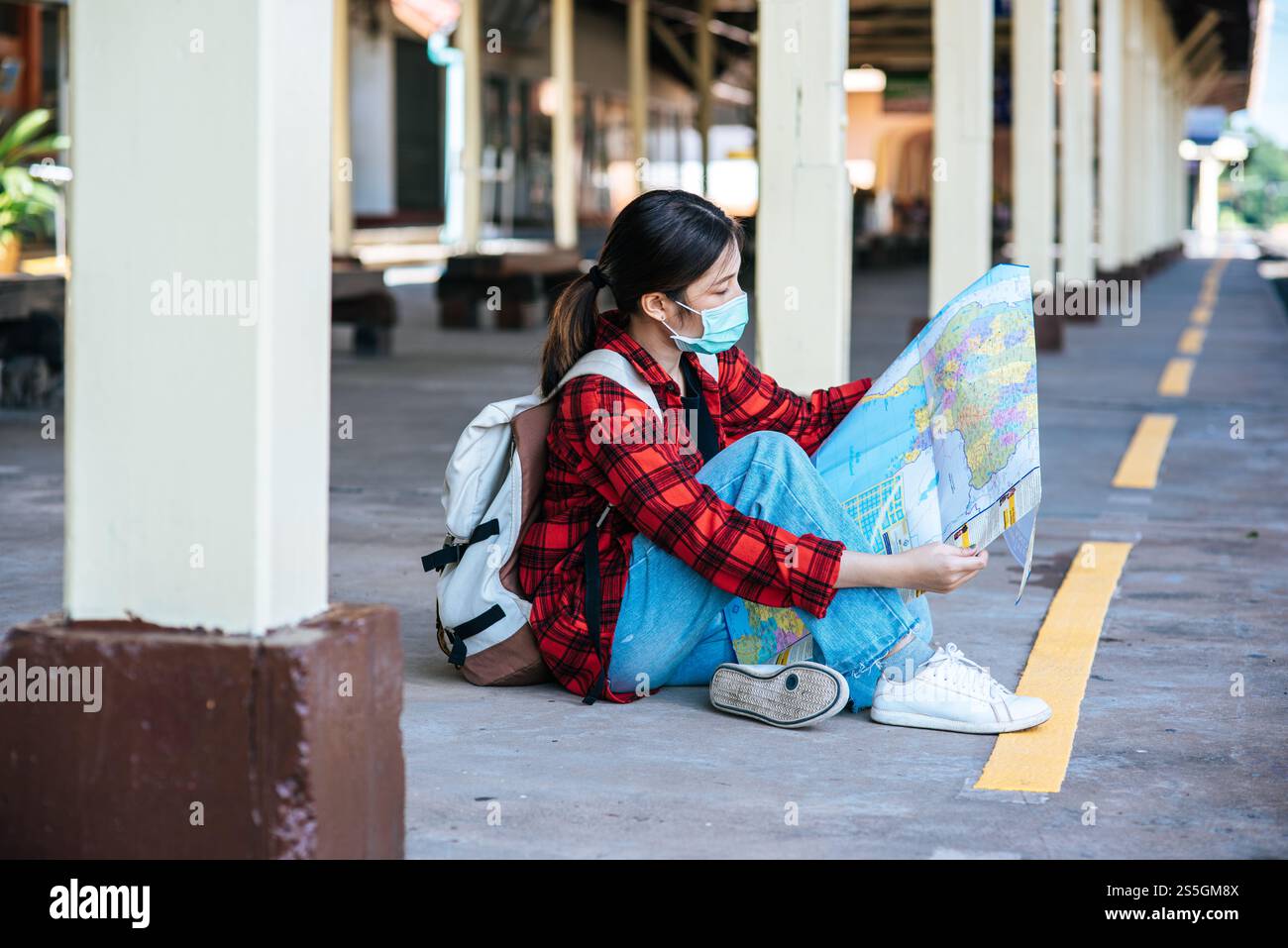Les touristes féminins s'assoient et regardent la carte sur le sentier à côté du chemin de fer. Banque D'Images