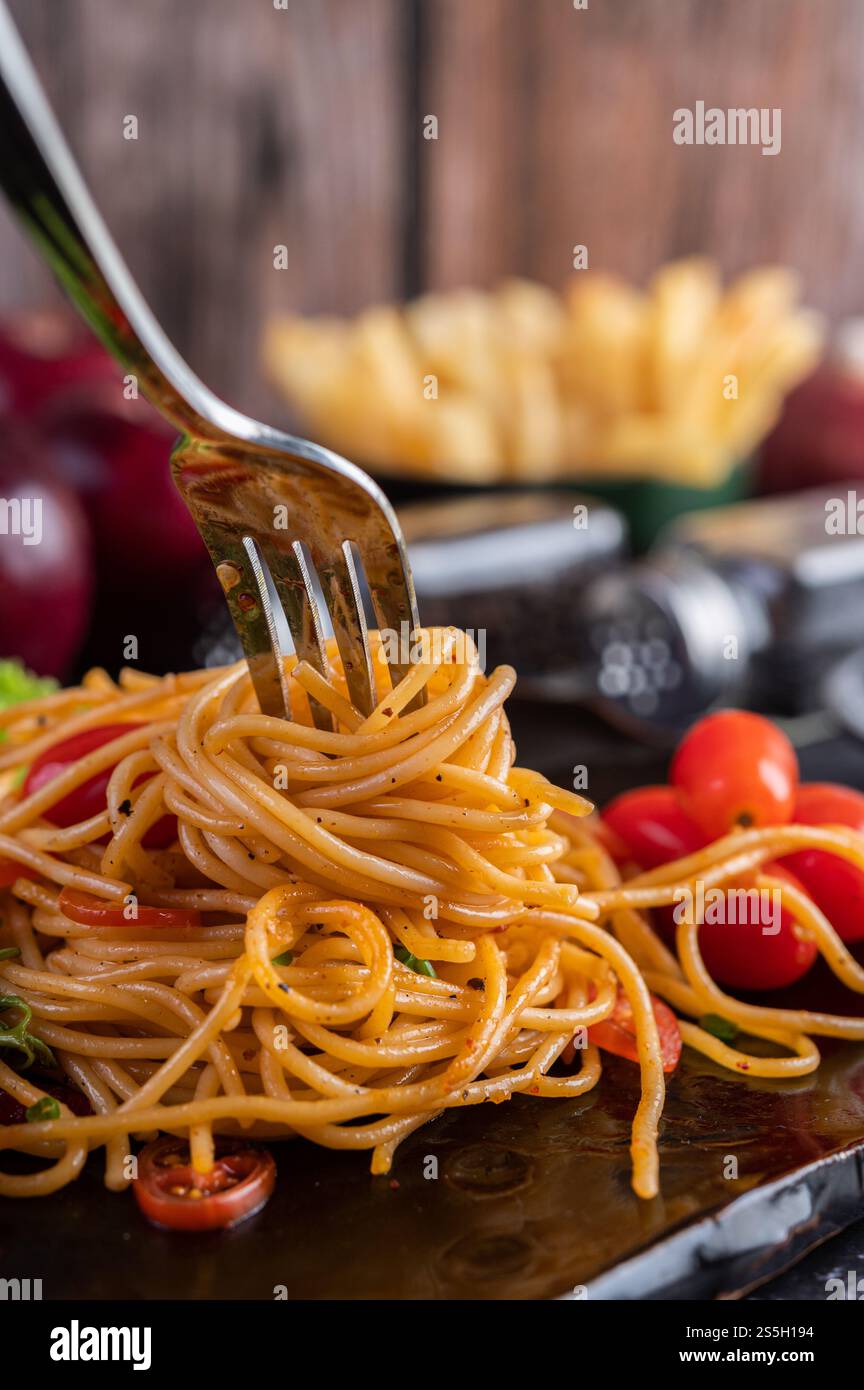 Spaghetti dans une tasse noire avec tomates et laitue. Mise au point sélective. Banque D'Images Spaghetti dans une tasse noire avec tomates et laitue. Mise au point sélective. Banque D'Images