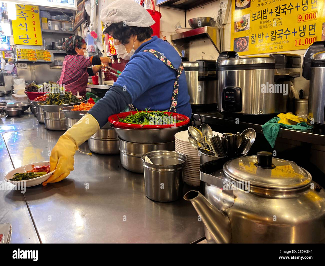 Vendeur de nourriture de rue cuisinant de la nourriture coréenne sur un stand de marché dans Kalguksu Alley dans le marché Namdaemun à Séoul, Corée du Sud. Banque D'Images