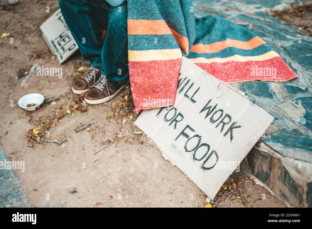 un homme assis mendiants avec des sans-abri s'il vous plaît message d'aide. Mise au point sélective. Banque D'Images