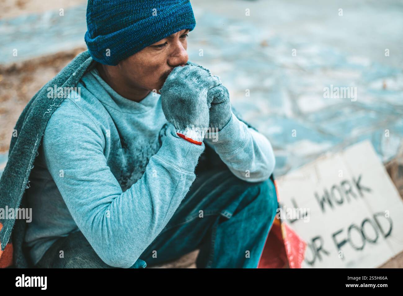 un homme assis mendiants avec des sans-abri s'il vous plaît message d'aide. Mise au point sélective. Banque D'Images