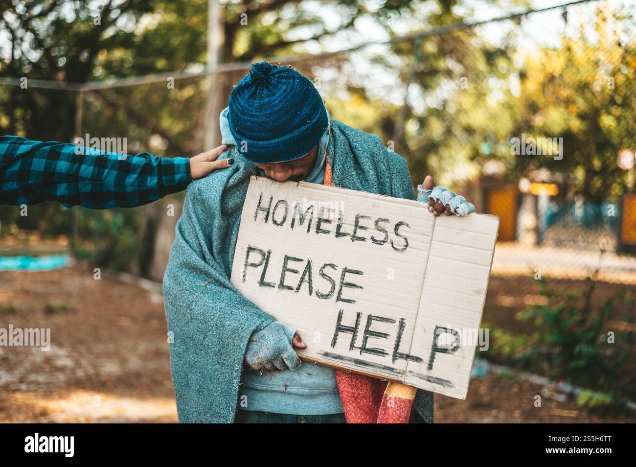 Mendiant debout dans la rue avec des messages pour les sans-abri s'il vous plaît aider. Banque D'Images