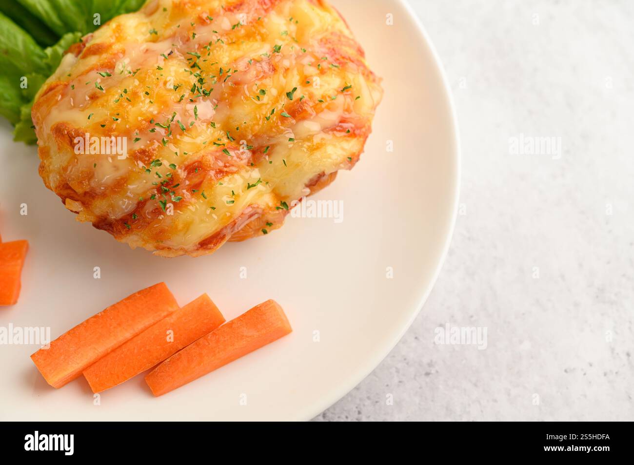 Vue de dessus et gros plan avec pain à la saucisse dans un plat blanc avec carotte, espace de copie Banque D'Images