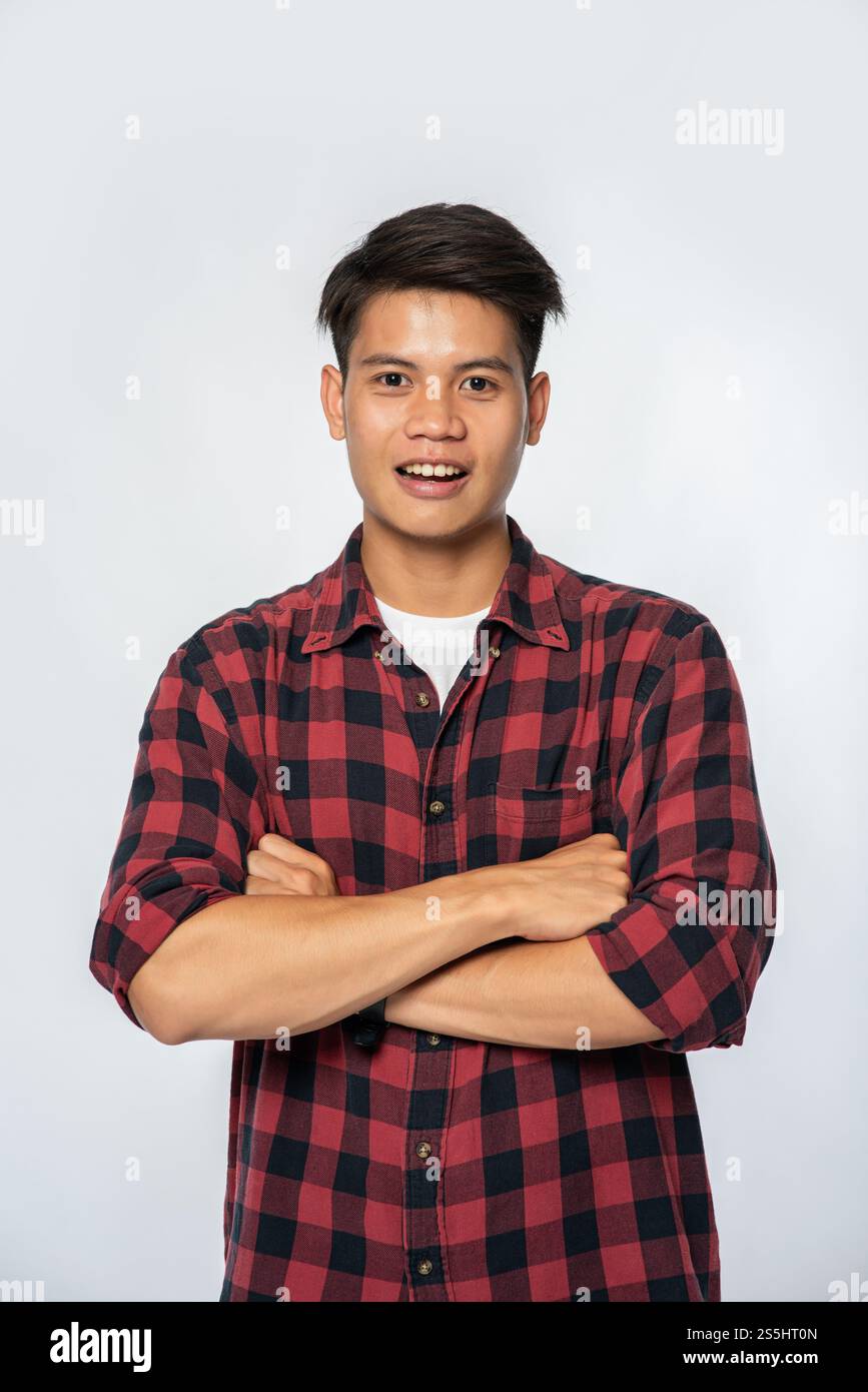 L'homme rayé se tenait debout, les bras pliés et choqués. Banque D'Images