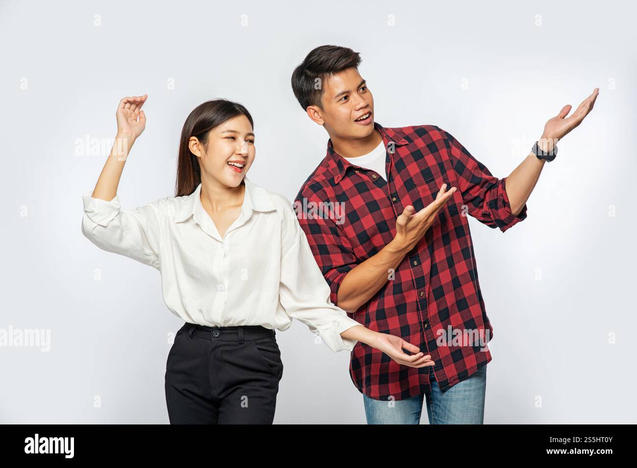 Les hommes et les femmes portaient des chemises et tenaient heureusement leurs mains sur le côté. Banque D'Images