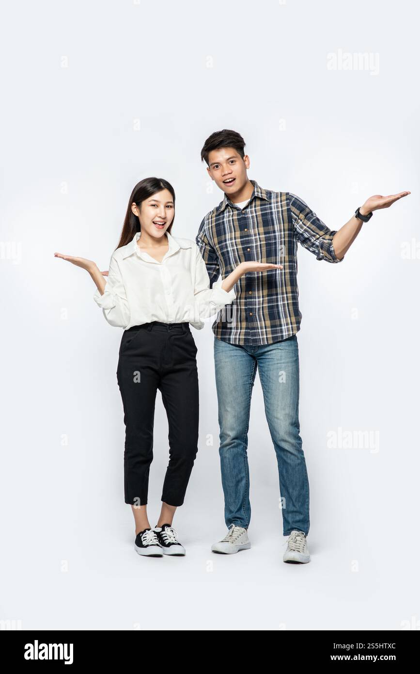 Les hommes et les femmes portaient des chemises et tenaient heureusement leurs mains sur le côté. Banque D'Images
