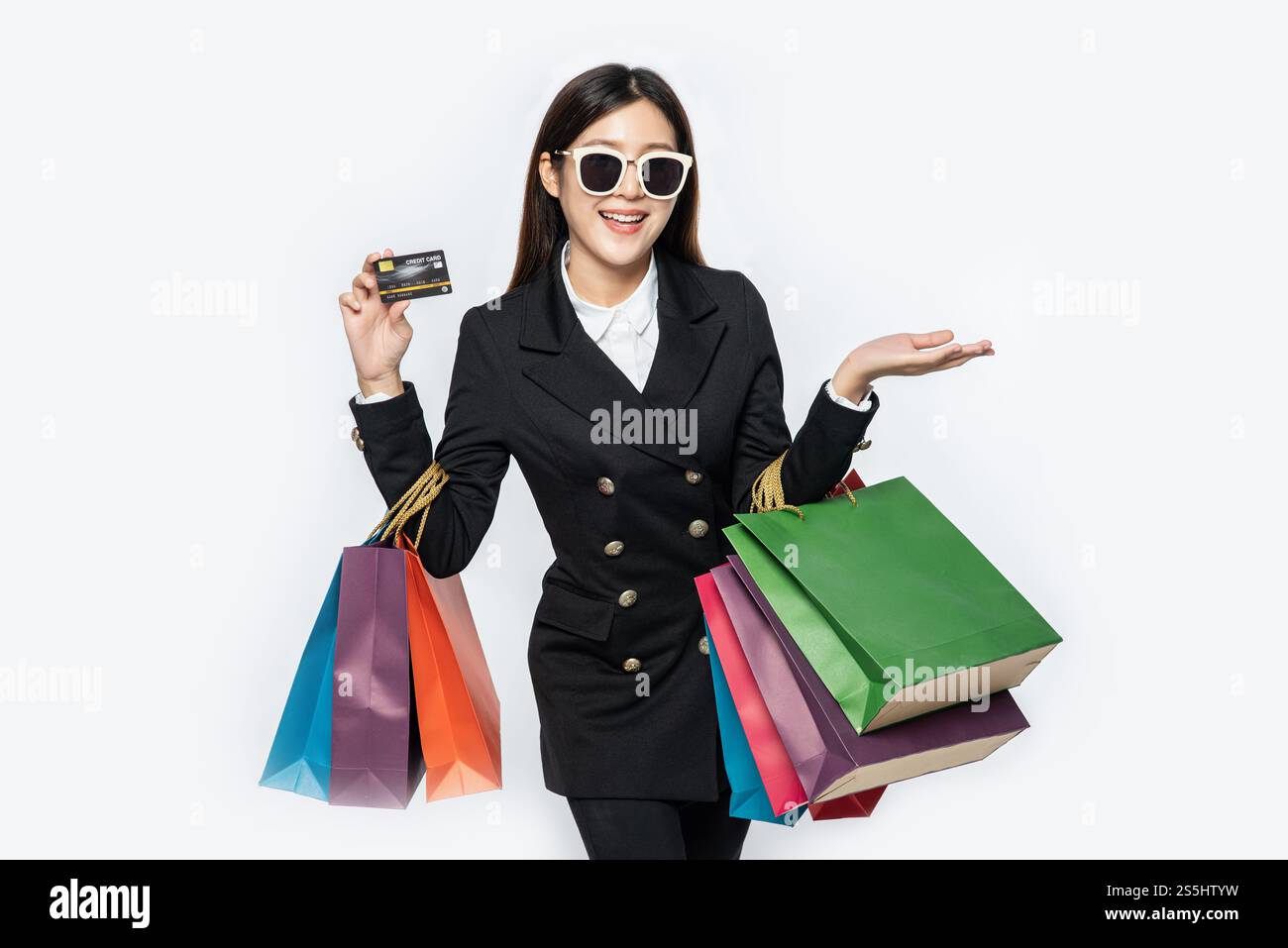 Les femmes en noir portent des lunettes, font du shopping, portent des cartes de crédit et beaucoup de sacs. Banque D'Images