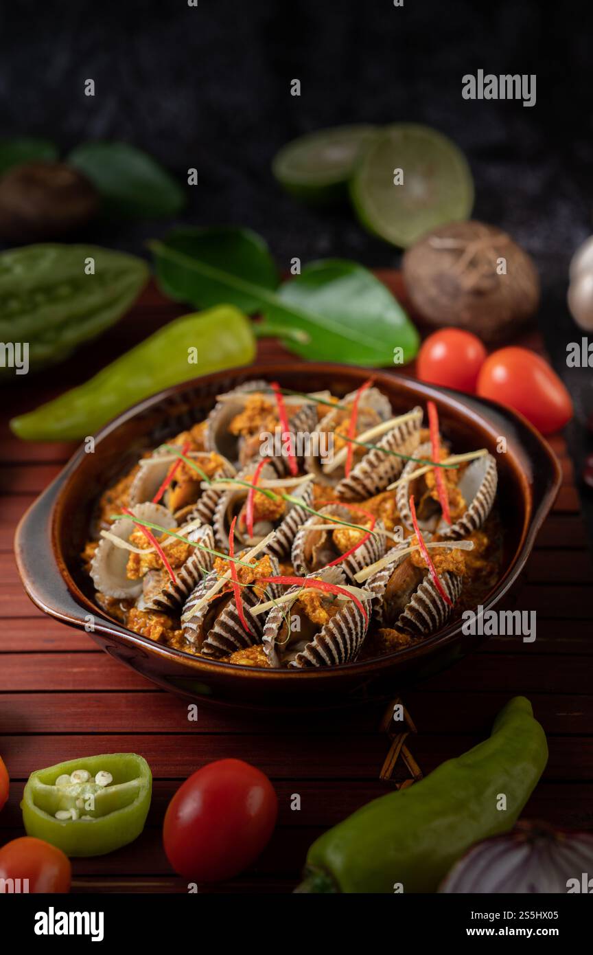 Coques sautées dans de la poudre de curry avec des poivrons et des tomates. Banque D'Images