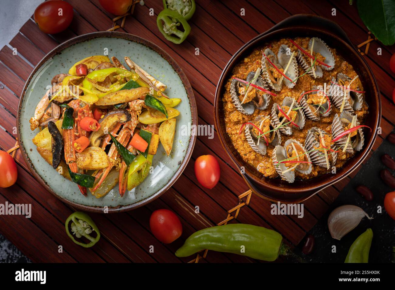 Coques sautées dans de la poudre de curry avec des poivrons et des tomates. Banque D'Images