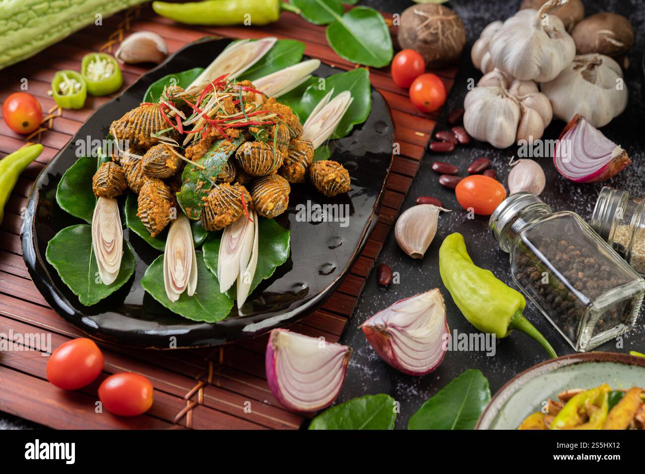 Coques sautées dans de la poudre de curry avec des poivrons et des tomates. Banque D'Images