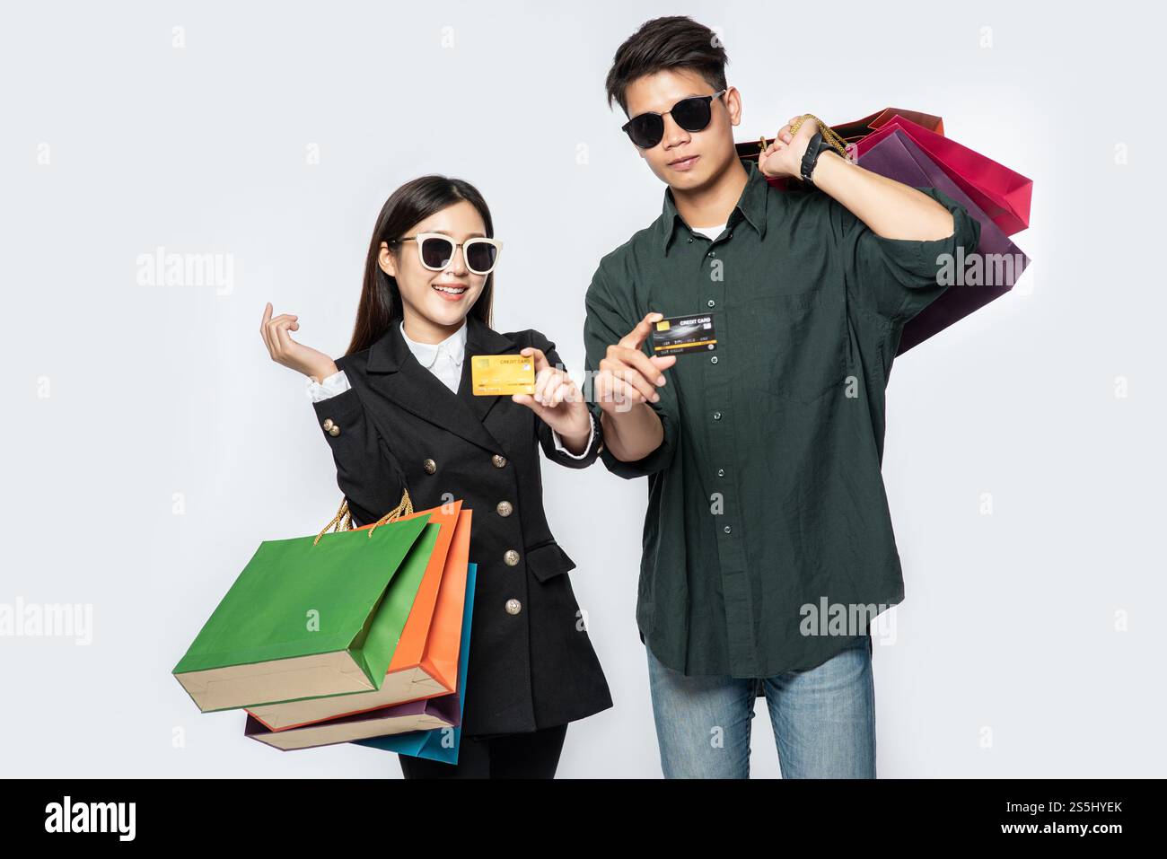 Une paire d'hommes et de femmes portaient des lunettes et transportaient beaucoup de sacs en papier pour faire du shopping. Banque D'Images