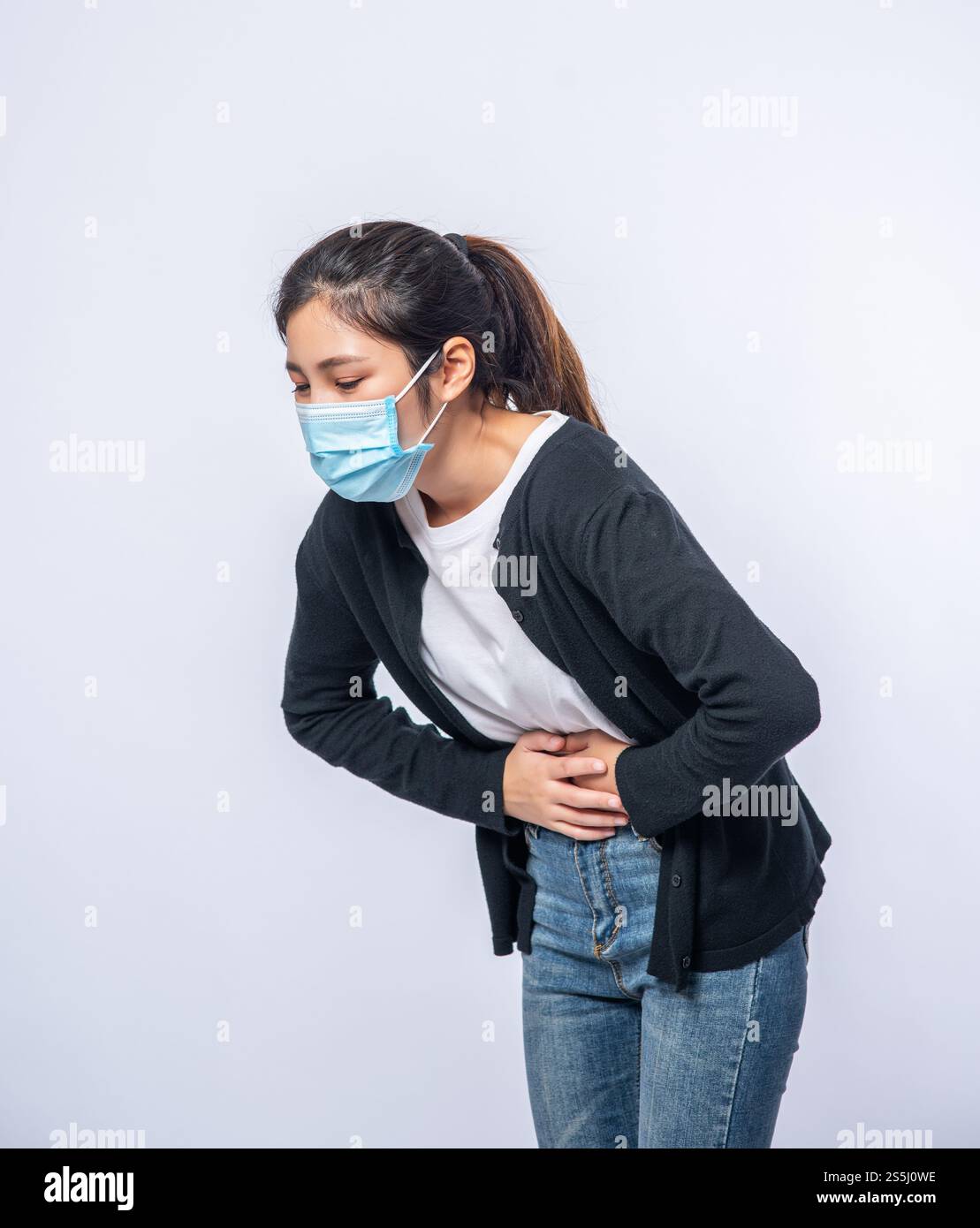 Une femme debout avec un mal de ventre et appuie sa main sur son ventre. Banque D'Images