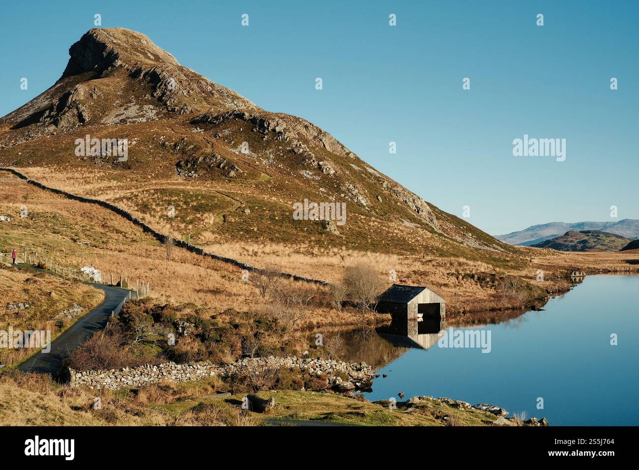 Une maison de bateau se trouve au bord des lacs de Cregennan, ou Llynnau Cregennan, près d'Arthog, Dolgellau, au nord du pays de Galles avec la crête de Pared y Cefn hîr au-dessus Banque D'Images