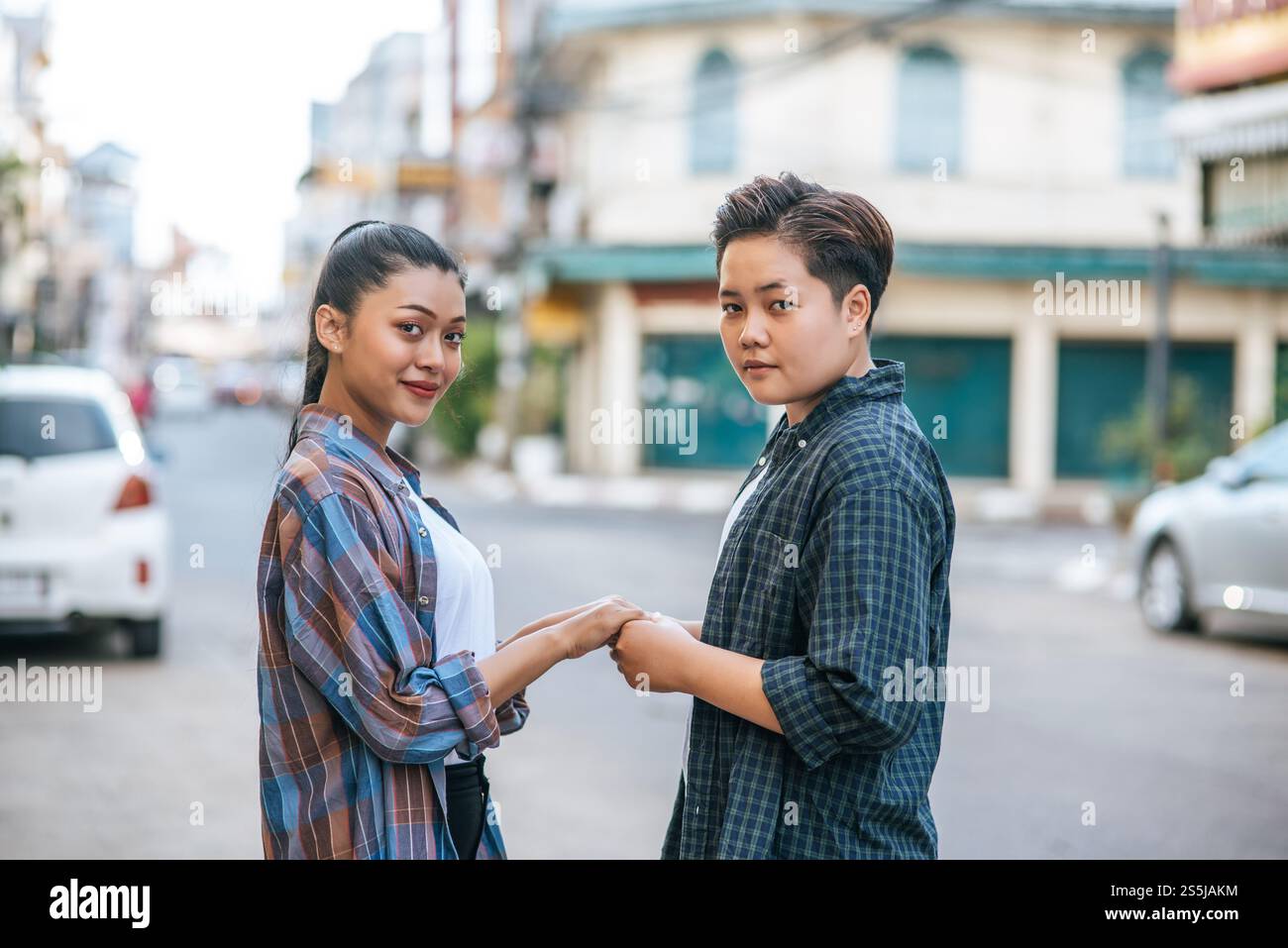 Deux femmes aimantes debout et tenant la main dans la rue. Banque D'Images