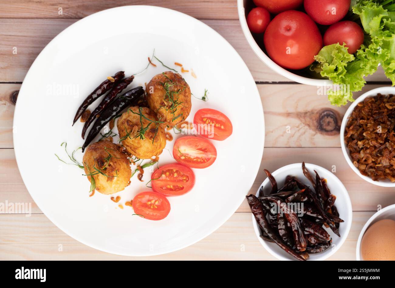 Œufs durs sautés avec sauce au tamarin, nappés d'oignons frits et de piments secs, gendre, cuisine thaïlandaise. Banque D'Images