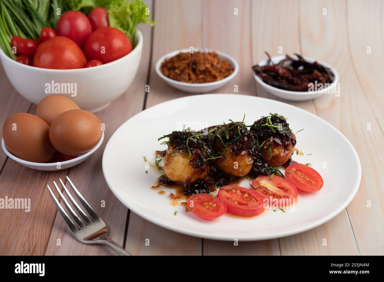 Œufs durs sautés avec sauce au tamarin, nappés d'oignons frits et de piments secs, gendre, cuisine thaïlandaise. Banque D'Images