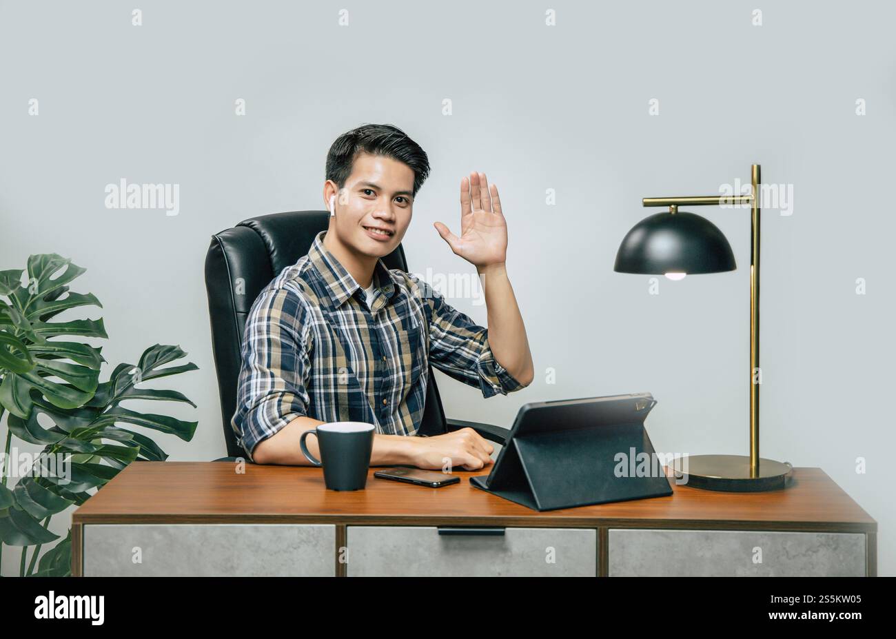 Heureusement jeune homme beau avec une nouvelle normalité, rester à la maison et travailler à partir de la maison sur tablette numérique et utiliser smartphone pendant l'auto-isolement et Banque D'Images
