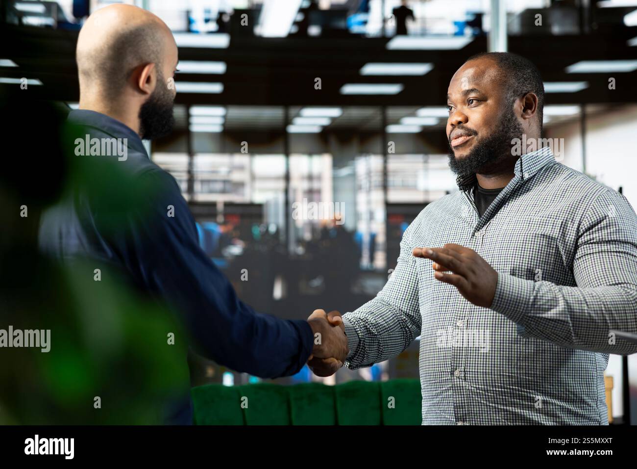 Des responsables commerciaux sympathiques assistent à une réunion d'information avec le PDG pour partager de nouvelles idées de croissance des bénéfices, serrant la main. Homme parlant au directeur pour expliquer la vision de l'évolution des startups, faisant une poignée de main Banque D'Images