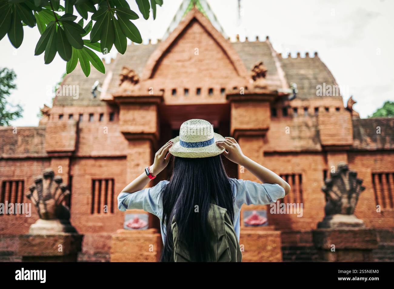 Vue arrière de la jeune femme de routard asiatique avec les cheveux longs noirs portant chapeau debout fourmi regardant le beau site antique ou le vieux temple pendant Banque D'Images