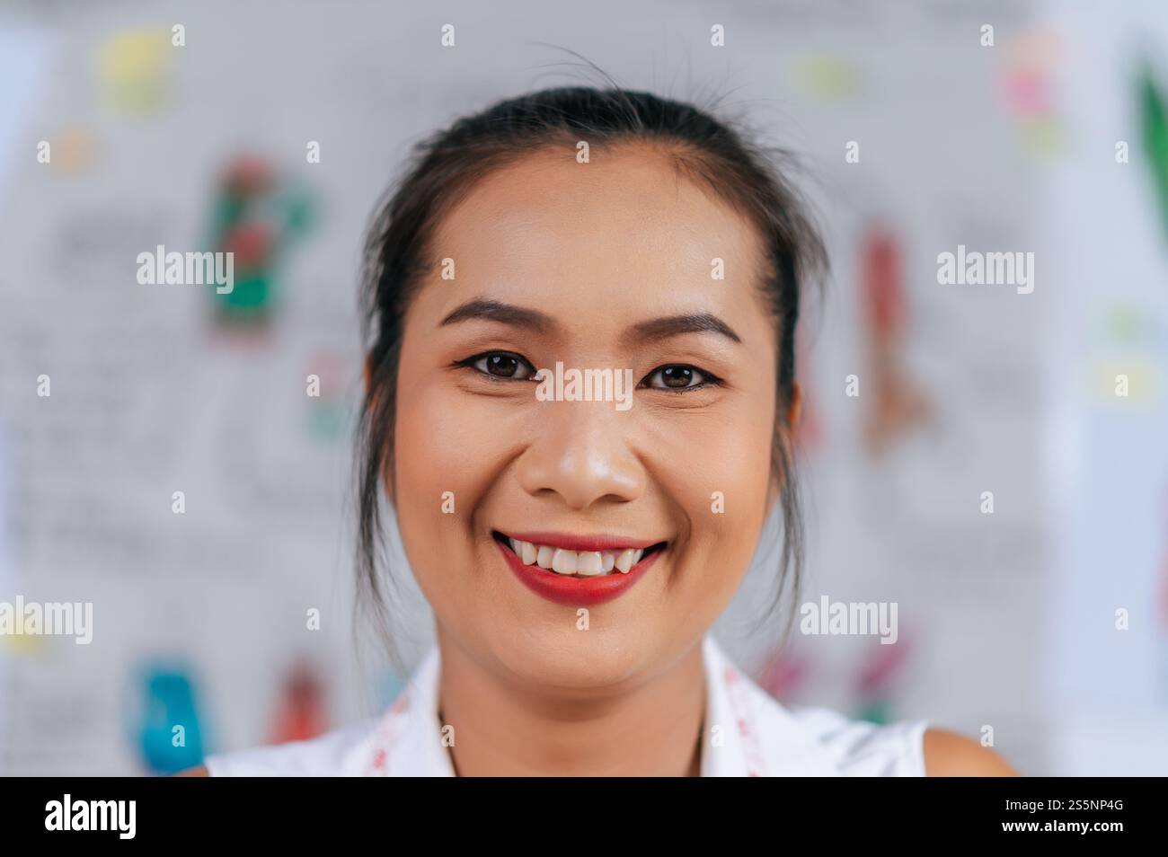 Portrait en tête de beau jeune créateur de mode sourire et à la recherche de la caméra avec Happy dans le magasin de tailleur Banque D'Images