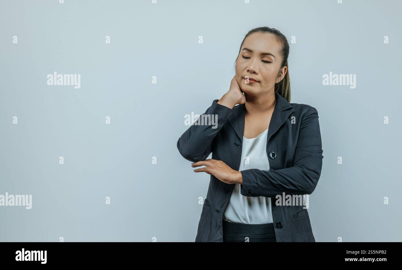 Portrait de femme d'affaires asiatique avec les bras pliés et toucher le cou isolé sur fond en studio. Banque D'Images