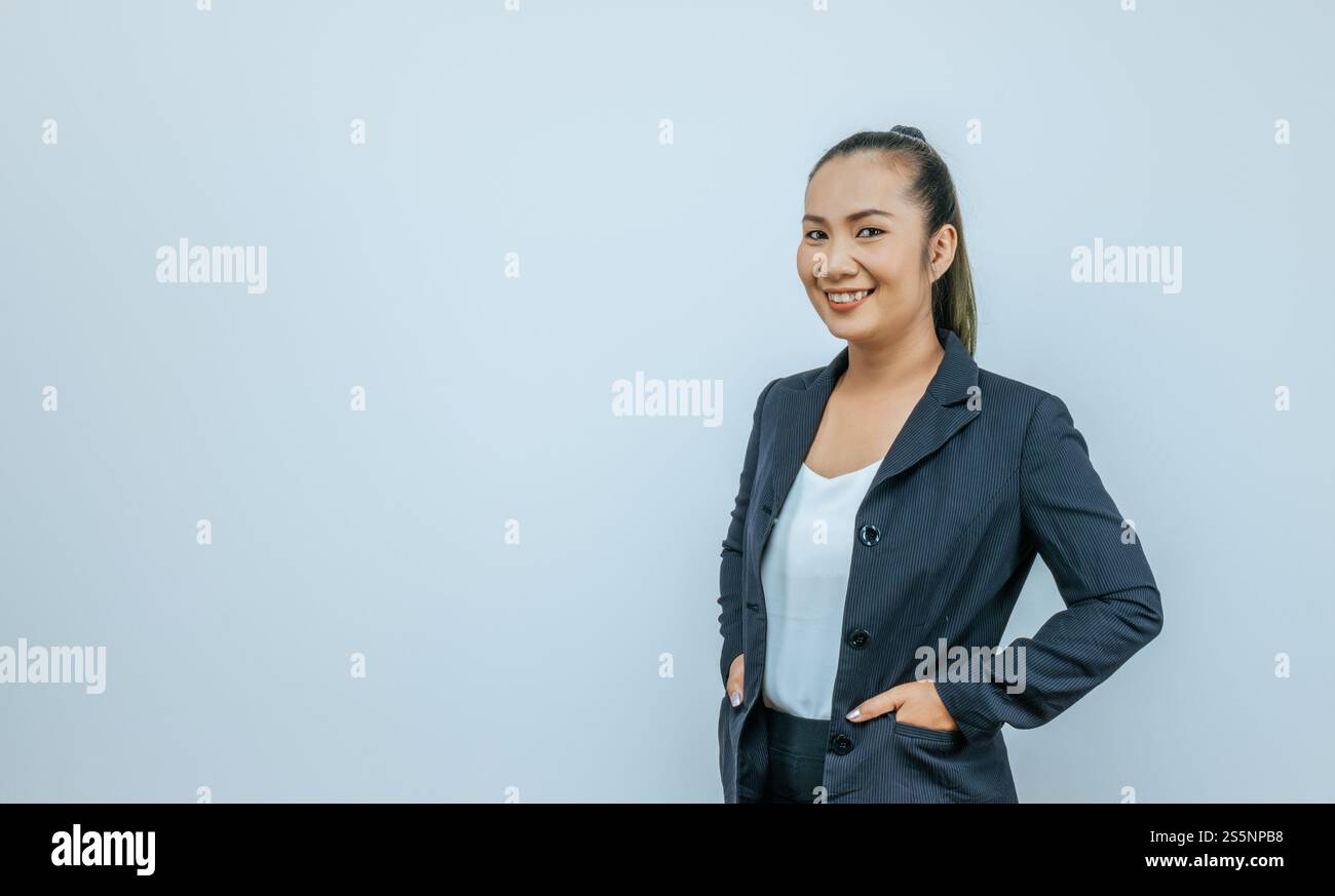 Femme asiatique confiante souriante, regardant la caméra posant sur fond avec un espace vide. Portrait studio de femme amicale réussie en blazer, Banque D'Images
