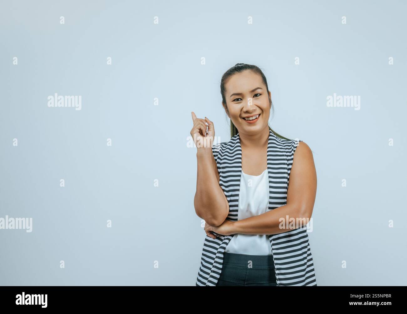 Portrait d'une femme asiatique portant des vêtements décontractés avec un grand sourire sur le visage, pointant avec la main et le doigt sur le côté regardant l'appareil photo isolé Banque D'Images