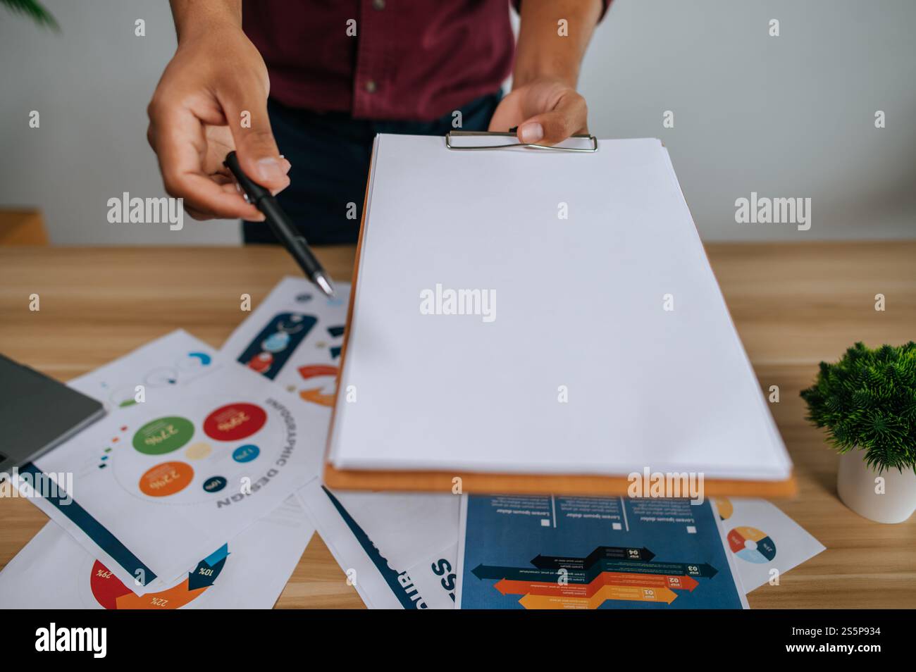 Un employé masculin a remis un dossier et un stylo à un autre employé pour faire une présentation. Banque D'Images Un employé masculin a remis un dossier et un stylo à un autre employé pour faire une présentation. Banque D'Images