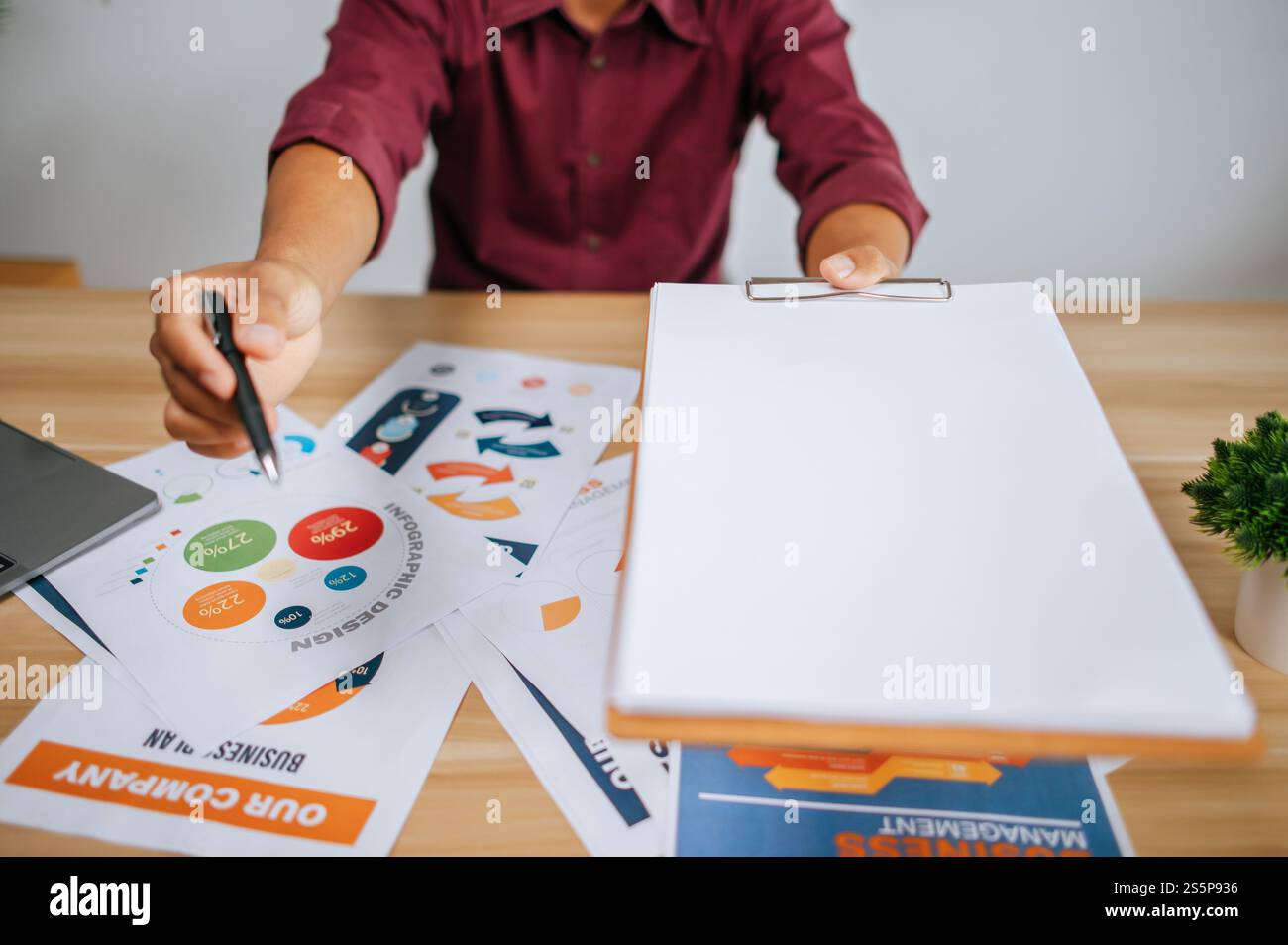 Un employé masculin a remis un dossier et un stylo à un autre employé pour faire une présentation. Banque D'Images Un employé masculin a remis un dossier et un stylo à un autre employé pour faire une présentation. Banque D'Images