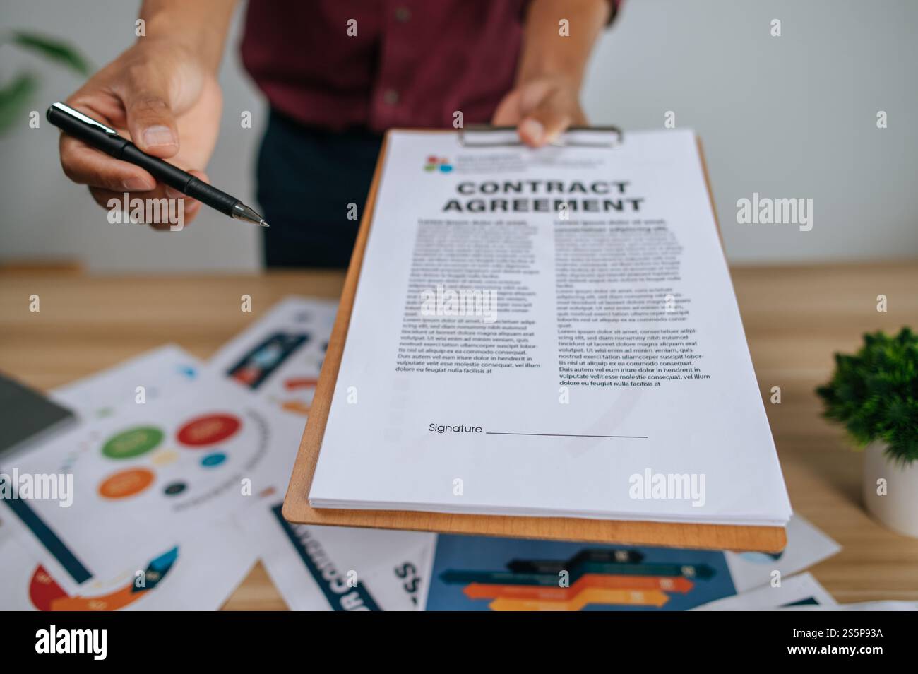 Un employé masculin a remis un dossier et un stylo à un autre employé pour faire une présentation. Banque D'Images Un employé masculin a remis un dossier et un stylo à un autre employé pour faire une présentation. Banque D'Images